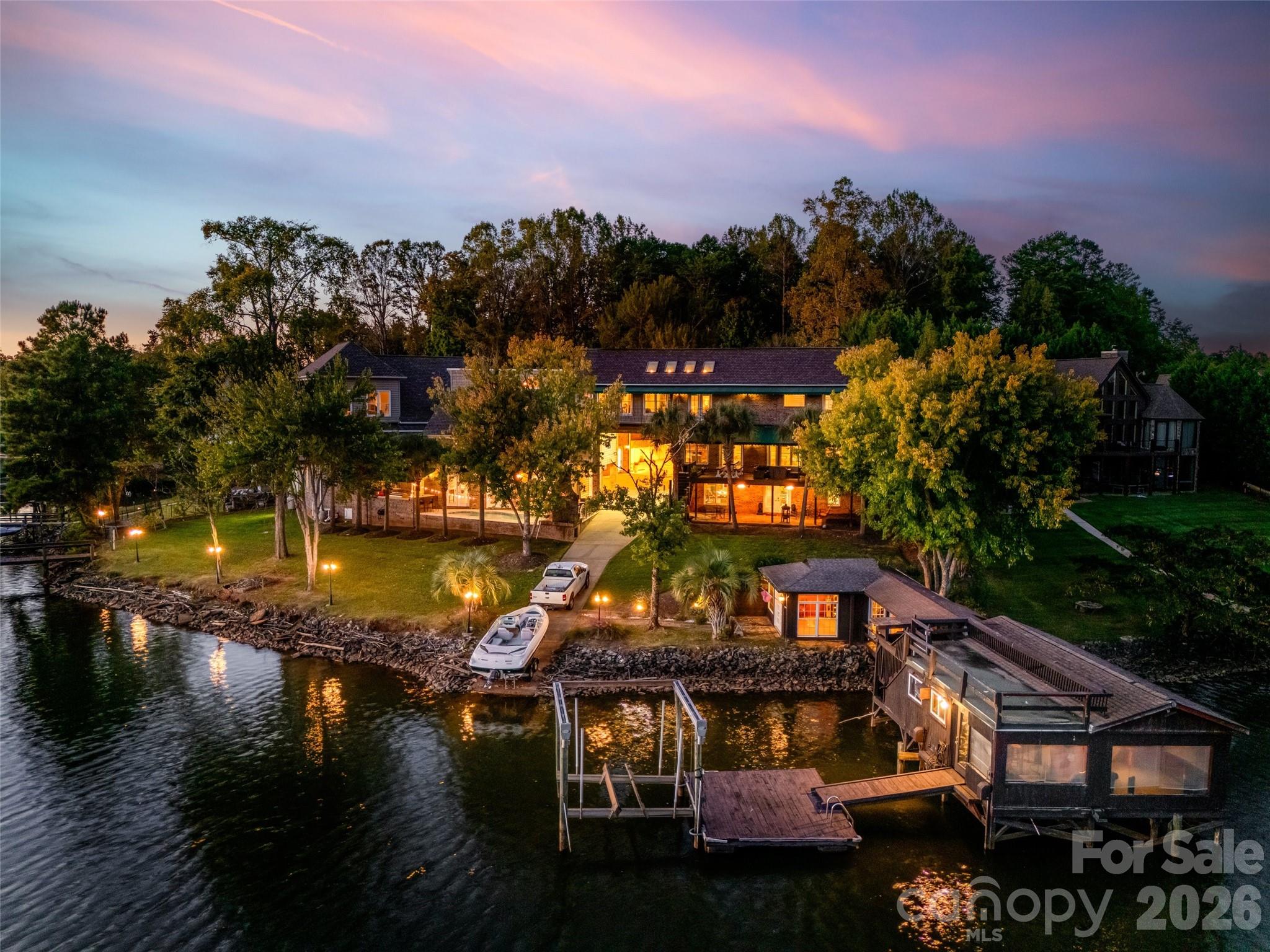 Unique custom-built waterfront home on Lake Wylie, perfect for a large family or those who love to entertain. This exceptional property offers beautiful lake views throughout and includes two private docks (one with a boat lift), a private boat ramp, and a boathouse featuring its own kitchen area. Enjoy the beautiful Gunite pool overlooking the lake and relaxing outdoor fireplace to relax and enjoy.

The main residence boasts an open great room with a fireplace, a gourmet kitchen with commercial-grade stainless appliances and a hibachi stovetop, a wet bar, and a walk-in butler’s pantry that leads to a large Trek deck overlooking the water. The primary suite offers vaulted skylights, a private balcony, dual walk-in closets, a fireplace, and a private sitting room with a wet bar. Additionally, the walk-out finished basement includes a separate bedroom and full bathroom leading to a private brick patio.

The property also features two distinct wings:

- Guest/In-law Suite: Attached to the main home with a private entrance, featuring a large living area, bedroom, bathroom, and full kitchen.
- Extended Wing: Includes a custom library/office with a fireplace, theater room, a second great room, a full kitchen, and a bathroom with a sauna. This wing leads to a Gunite pool, outdoor kitchen, and fireplace, as well as a lounge and private theater room.

Ample storage is provided by several garages. One garage includes built-in cabinets, while the larger attached garage wing features a 50-AMP RV/camper hookup and extensive space for multiple vehicles, hobbies, and work.