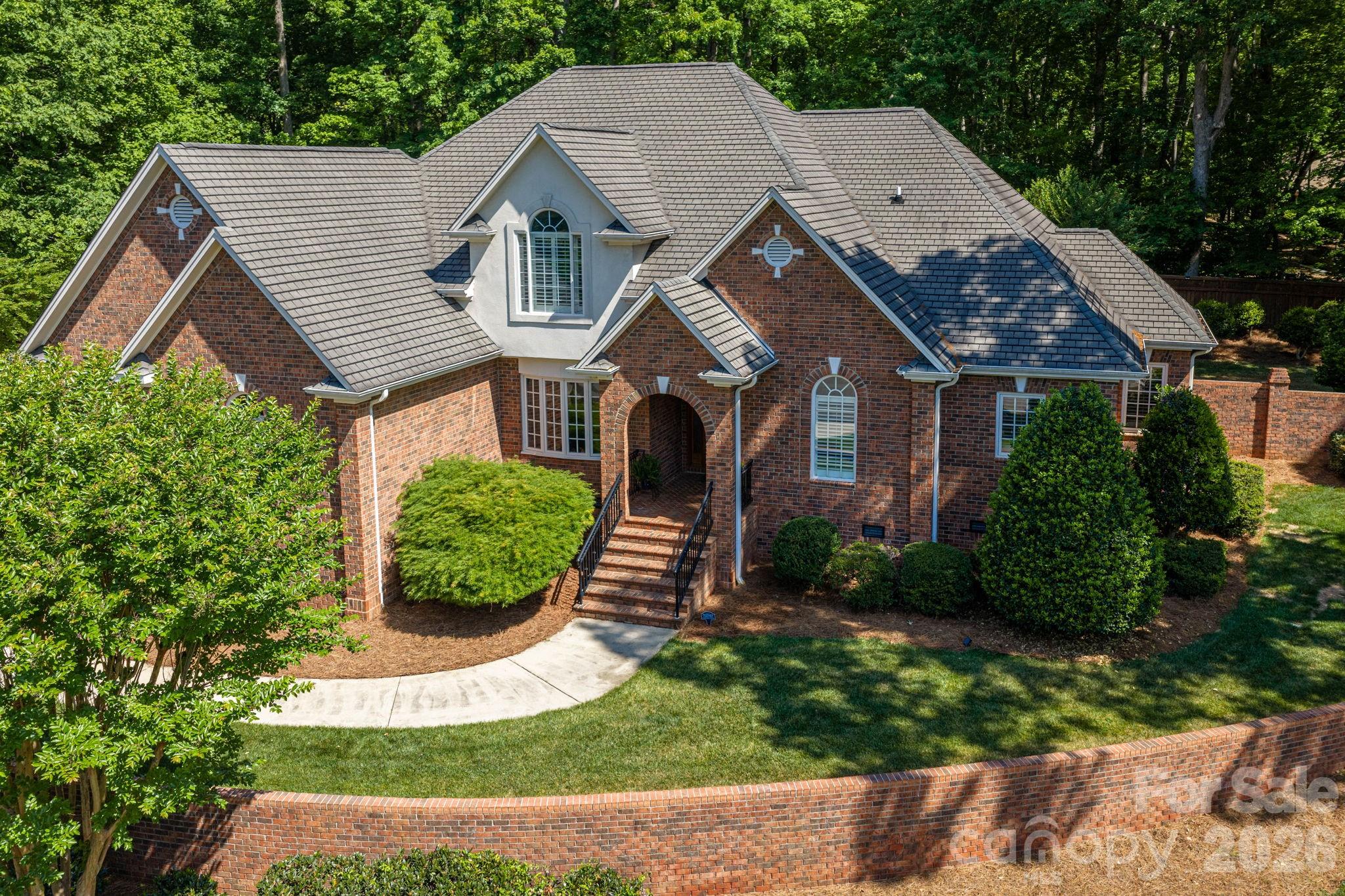 Timeless elegance meets everyday comfort in this beautifully maintained full-brick home. This home is perfectly situated on a quiet cul-de-sac lot in a charming established neighborhood. From the moment you arrive, the stately curb appeal, arched entryway, and mature landscape set the tone for what’s inside. Step through the custom-designed front door into a light-filled interior featuring hardwood floors, soaring ceilings, and a flowing layout ideal for both entertaining and daily living. The spacious living area features a rock fireplace and expansive windows, while the formal dining room adds classic charm with detailed trim and abundant natural light. A thoughtfully designed staircase connecting the foyer and kitchen creates an easy flow between spaces. The kitchen offers generous cabinetry, ample counter space, and a functional layout that opens seamlessly to the main living areas perfect for hosting gatherings or staying connected with family. The primary suite provides a relaxing retreat with a cozy sitting area and a large primary bath with spacious walk-in closet. Additional bedrooms are generously sized with flexible options for guests, home office, or bonus space. Enjoy outdoor living with a beautifully maintained yard with full irrigation, mature trees and peaceful surroundings ideal for morning coffee or evening entertaining. The oversized two car detached garage is heated and cooled making it ideal for that perfect workshop you've always wanted. Conveniently located near shopping, dining, and commuter routes with Charlotte Douglas Airport approximately 20 minutes away. This home combines classic style, space, and location in one exceptional package!