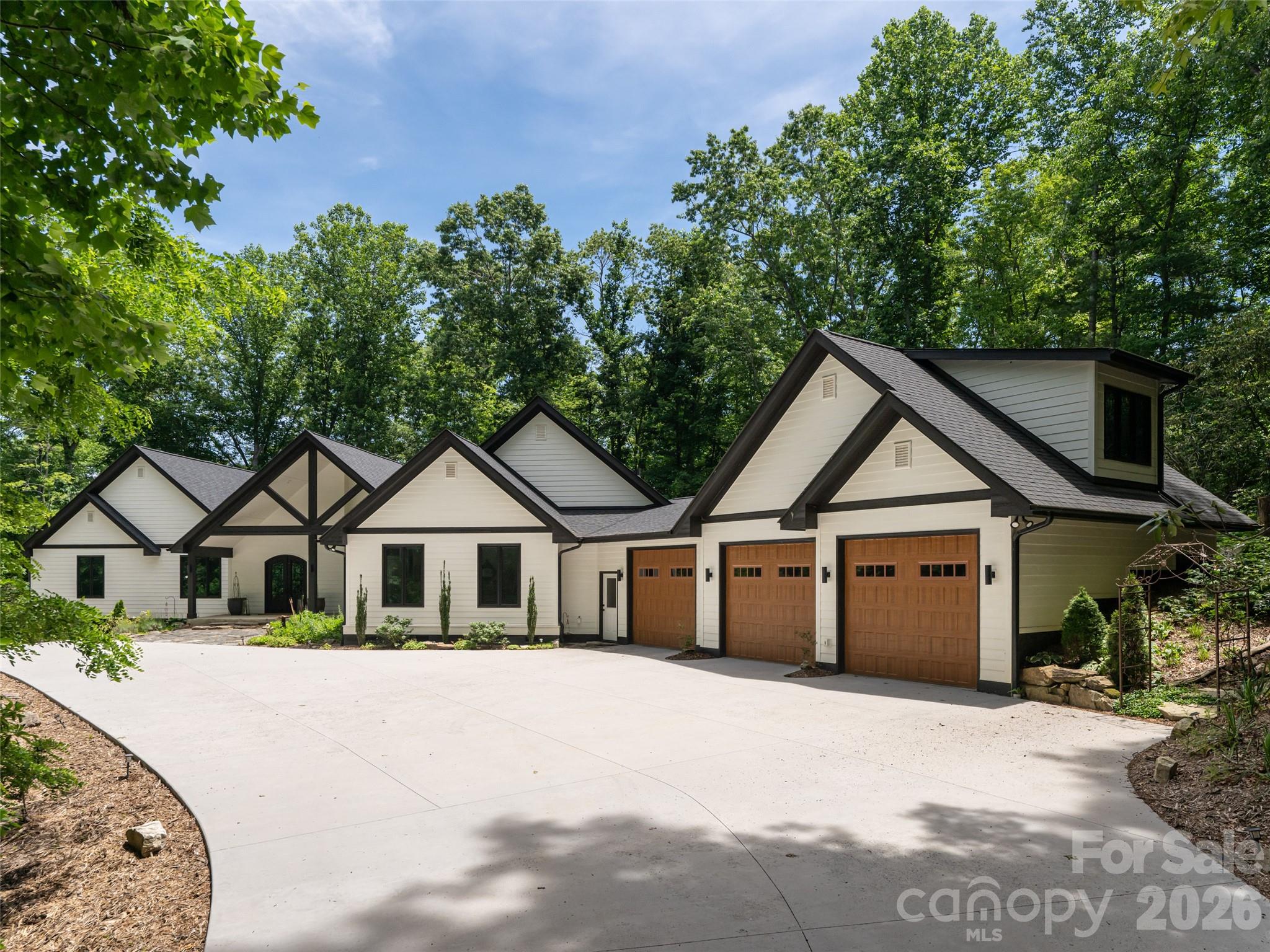 Experience the pinnacle of mountain living in this meticulously reimagined estate, where 10 natural, private, low-maintenance acres serve as your personal gateway to Pisgah National Forest. More than a renovation, this is a masterclass in craftsmanship and quiet luxury. The interior glows with natural light through new wood windows, highlighting regenerative Seringa wood flooring and Brazilian black slate tile. The chef's kitchen is a culinary showpiece featuring Brazilian granite, a Thor cooktop, and GE Cafe double ovens with warming drawer. Retreat to the luxurious owner's suite, a private sanctuary designed for ultimate relaxation with a private deck, spacious his and hers closets, and a spa-like ensuite with soaking tub and walk-in shower with dual shower heads. The 470 sq. ft. gym, located above the garage, is heated/cooled, bringing the total heated living area to 4,436 sq. ft. Outside, expansive new decking and a screened patio with a natural fireplace offer 180-degree winter views and summer shade. A meandering creek, walking bridge, 2 large and versatile barns, and a pasture complete this picturesque setting, and with the trails, this could be a perfect equestrian property. Modern infrastructure includes new dual HVAC systems, on-demand water heating, and a 3.5+car garage. This is a rare legacy property minutes from South Asheville amenities.  Deed restrictions allow for 2 additional single family homes, making it a perfect property for a family compound!