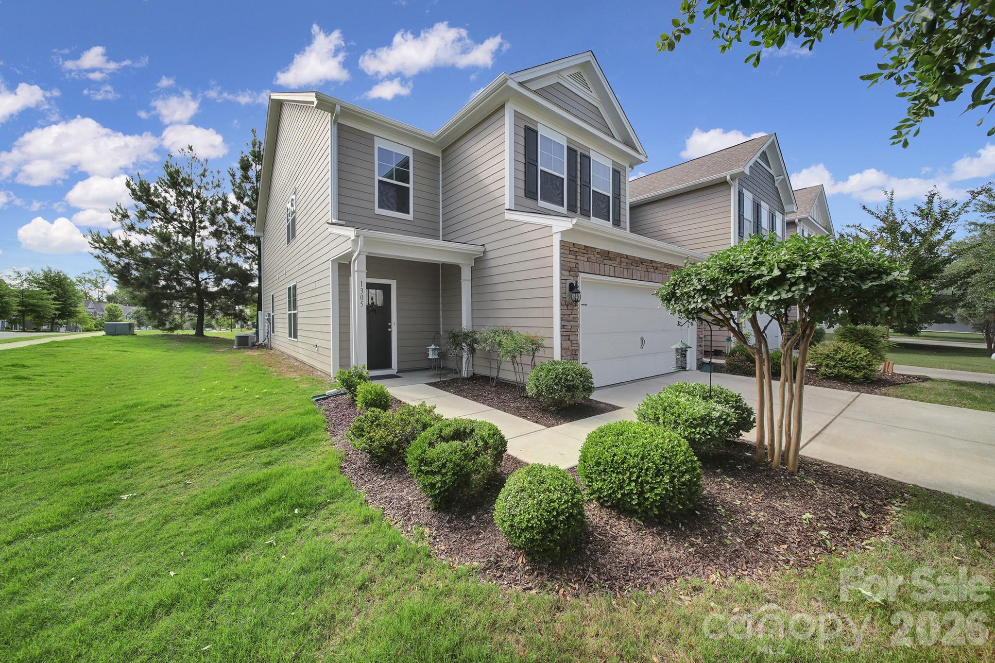 Desirable Forest Grove Community — North-facing corner-unit townhome! A two-story entry opens to sun-filled living spaces with wood flooring throughout living areas. The main-level primary suite features a striking accent wall for a designer touch. The chef’s kitchen showcases white custom cabinetry, subway tile backsplash, granite countertops, a large island with breakfast bar, stainless steel appliances, a gas cooktop, and a refrigerator that conveys. Enjoy an open-concept layout connecting the kitchen, dining, and living areas—perfect for everyday living and entertaining. Upstairs offers a spacious loft, three additional bedrooms, and a full bath with dual sinks and tile flooring. Additional features include a 2-car garage with epoxy flooring and shelving, an outdoor back patio, and a washer and dryer that convey. Termite bond included. Benefit from low South Carolina taxes and top-rated schools, with convenient access to shopping, restaurants, and more!