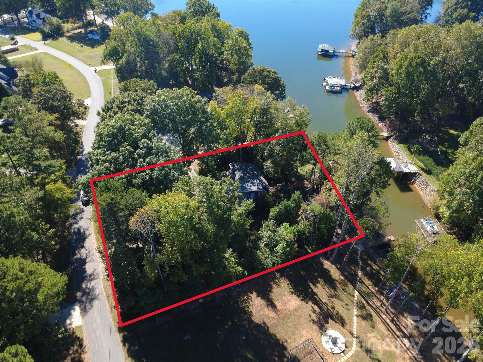 PRIME .71 ACRE LAKEFRONT BUILDING OPPORTUNITY with NO HOA!

Stop searching and start designing! This is a rare opportunity to acquire an expansive .71 acre waterfront lot perfectly positioned for the creation of your custom dream home on the lake. The value is squarely in the land, its lack of HOA restrictions, and the exceptional, pre-existing lake amenities.

This lot is situated on an amazing cove, offering a distinct advantage for lake lovers. A cove location provides shelter from heavy boat traffic and high winds, creating calmer waters perfect for paddleboarding and kayaking.
The property boasts an impressive 154 feet of shoreline and features a significant benefit: an existing private pier and floating dock are grandfathered-in and are conveyed with a permit, offering the legal entitlement to install a new and modern pier and dock structure for future enjoyment. The lot benefits from existing infrastructure, including an existing well and septic system. The generous lot size provides ample space for a significant luxury home, extensive landscaping, and outdoor living areas.

Investor and Builder Alert: The lot's superb features and location make it an excellent piece of inventory for a custom builder's portfolio. The existing structure and any additional structures are currently in need of extensive work and are being sold strictly AS-IS. The seller makes no representations regarding their condition or functionality.

Focus on the Future: Don't miss this chance to secure a coveted, unrestricted piece of lakefront paradise. The true value is the dirt and the dock permit! Buyer/Agent to verify all information, including the water depth, the condition and function of the existing well and septic system, and owner is working with Duke Energy to provide the status/transferability of the pier and dock permit.