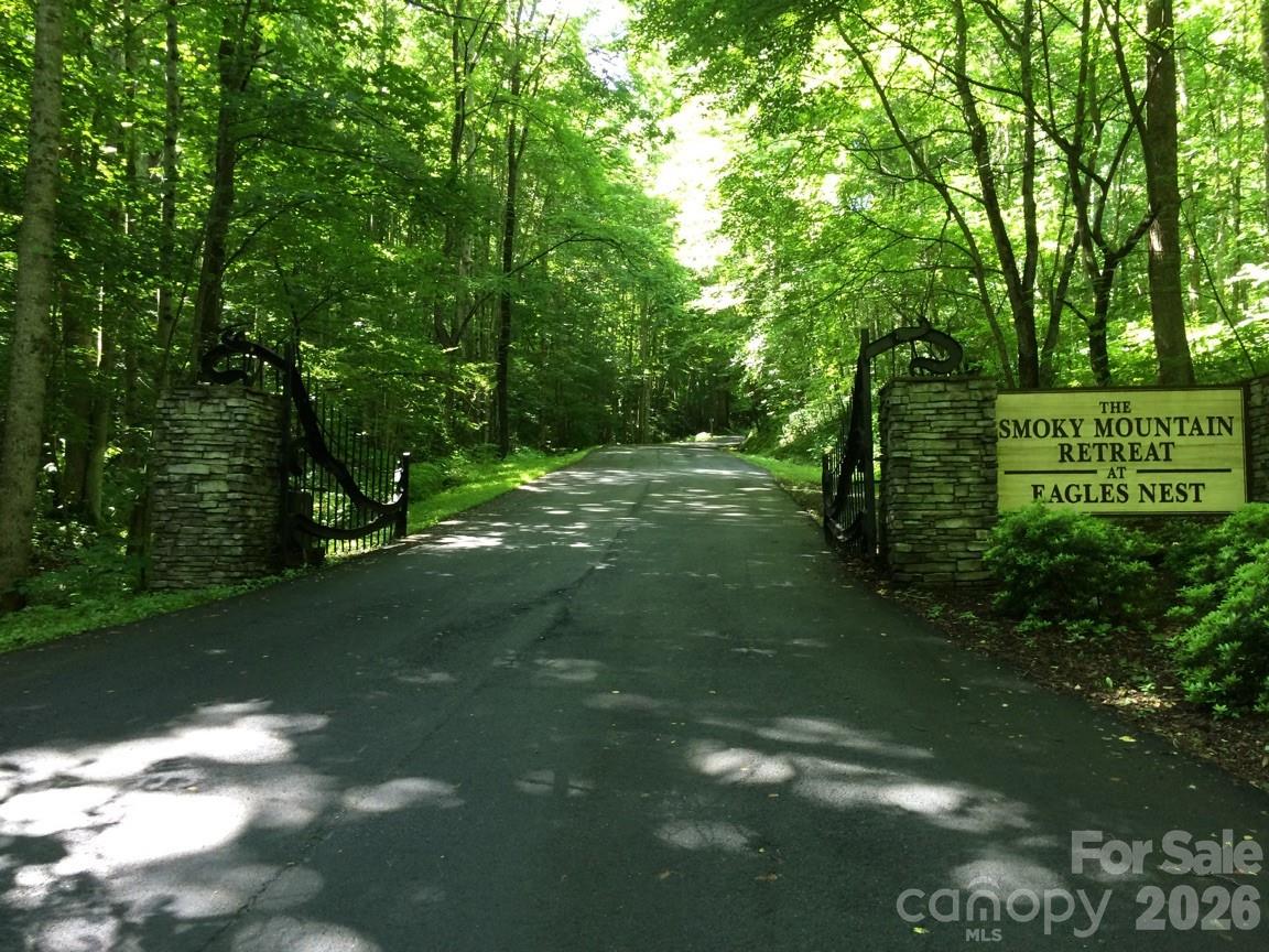 This premium lot offers exceptional mountain views of the Great Smokies at an elevation of over 4,500 feet. It is located within the Smoky Mountain Retreat at Eagles Nest, a luxury log home community. The community features a gated entrance, wide roads, spectacular views, a community center, and a playground. Additionally, the property is conveniently accessible from both Maggie Valley and Waynesville.