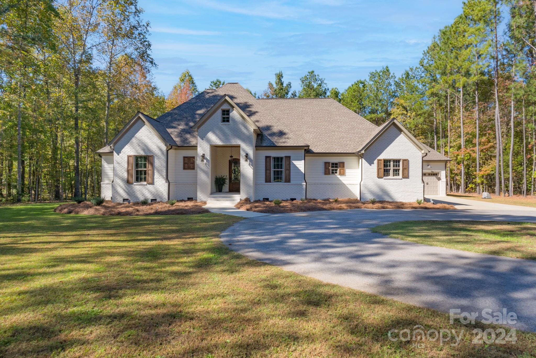 From the moment you drive up to this immaculate one-story home, you will realize it is a jewel! Step inside to find a great room with brick fireplace and gas logs, custom built-ins, and coffered ceiling that opens into the incredible kitchen with quartz countertops, gas range, stainless appliances, and large island. With a split floor plan, the primary suite features a grand bedroom and exquisite bath. Two additional bedrooms have their own bathrooms that allow private space for everyone. Make sure you check out the study with the secure storage closet. An additional flex space can be used as a playroom, office, or separate den/sitting area. The back covered porch is perfect for entertaining with vaulted wood ceiling, brick fireplace, and an outdoor grilling area. Finally, you will be enthralled with the FIVE bay garage space, including two that are equipped with their own heating/cooling units. The possibilities are unending on this private property nestled in the middle of 6.6 acres.