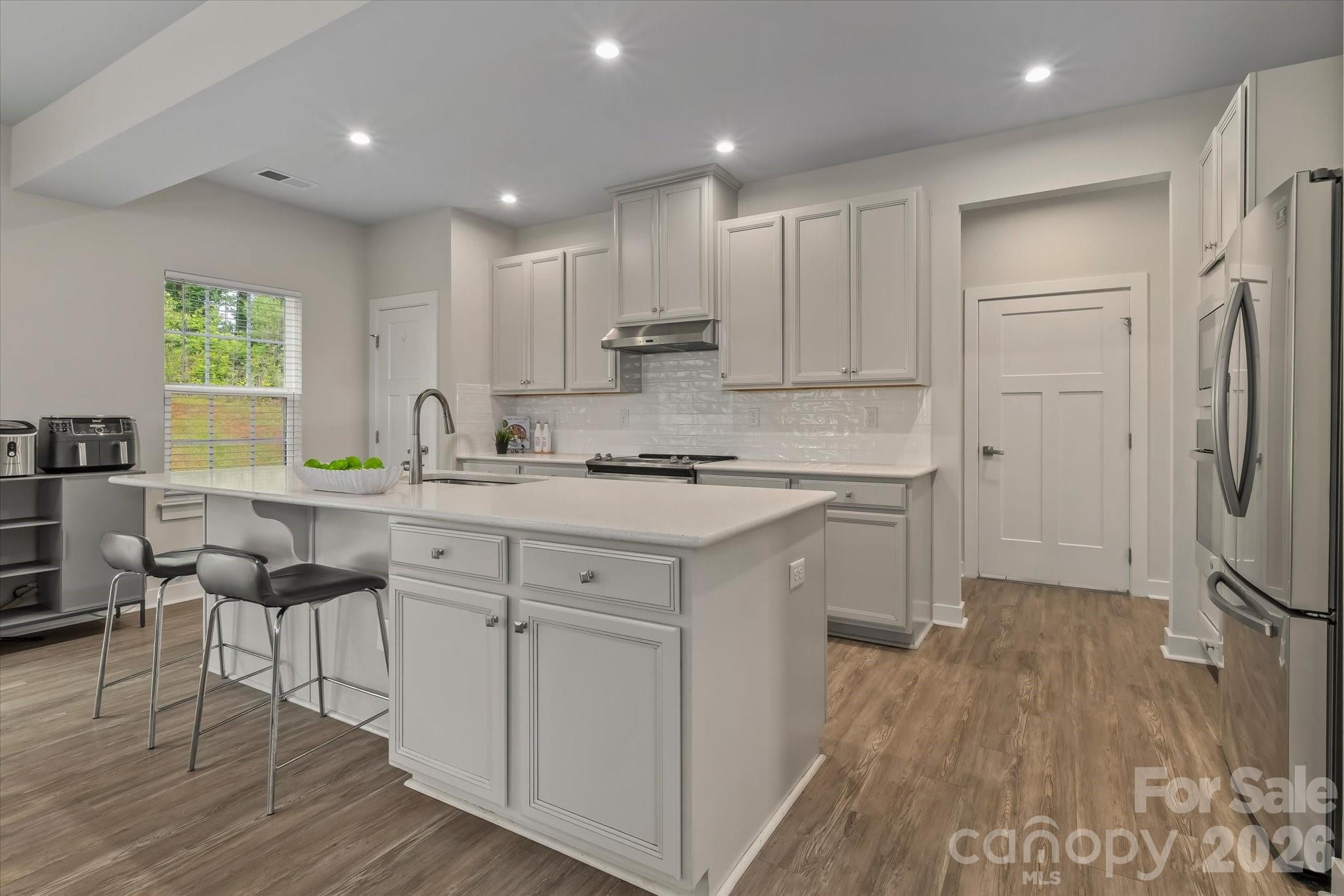 Seller offering $8,000 toward buyer closing costs or rate buy-down with an acceptable offer! One of the best values in Holcomb Woods, this 2020-built home offers 5 bedrooms, 3 full baths, and a flexible floor plan with a main-level bedroom and full bath, ideal for guests, work-from-home needs, or multigenerational living. The open-concept main level features quartz countertops, stainless steel appliances including a double oven, large kitchen island, LVP flooring throughout the main living areas, and comfortable spaces for everyday living and entertaining. Upstairs, the spacious primary suite is joined by three additional bedrooms and an upper-level laundry room. Situated on a premium .36-acre lot with a private wooded buffer on the right side, this home offers added privacy in a neighborhood setting. Holcomb Woods features sidewalks, a playground, and an outdoor pool, and the home is located in the superb Hickory Ridge school district with convenient access to shopping, dining, and commuter routes. With 5 bedrooms, a main-level guest suite, a premium lot, and seller credit available, this home is a smart opportunity in one of Harrisburg’s most desirable communities. Schedule your showing today.