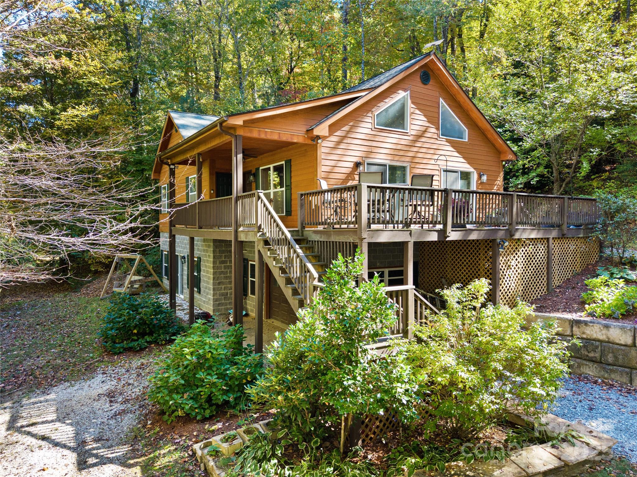 This “Mountain retreat” is nestled on a private 4-acre lot with lake Summit access.  The charming home has had quite a few renovations: new paint throughout, new carpet on main level, majority of lot is fenced in with gates installed, along with a tankless hot water heater and more.  It offers the perfect blend of tranquility and accessibility to Flat Rock, Hendersonville and short drive to Asheville or Upstate SC.  Covered front porch; large wrap-around deck off the dining area;perfect for enjoying the mountain air any time of day.  Spacious and open floor plan with cathedral ceilings in the living room, creating a bright and inviting gathering space.  The kitchen features ample cabinets, walk-in pantry, and a casual dining area — perfect for both everyday living and entertaining.  The main-level primary suite has a double closet, full bath including a soaking tub and separate shower.  The main level also has a guest bedroom, full bath and laundry.  The lower level expands your living footprint with a large family/entertainment zone, separate flex room with closet and full bath…endless possibilities.  The Full house generator just adds to the abundant features.  The home has excellent getaway appeal: the setting is ideal for those looking for a second home, vacation rental potential, or simply a full-time residence away from the busyness of city life.