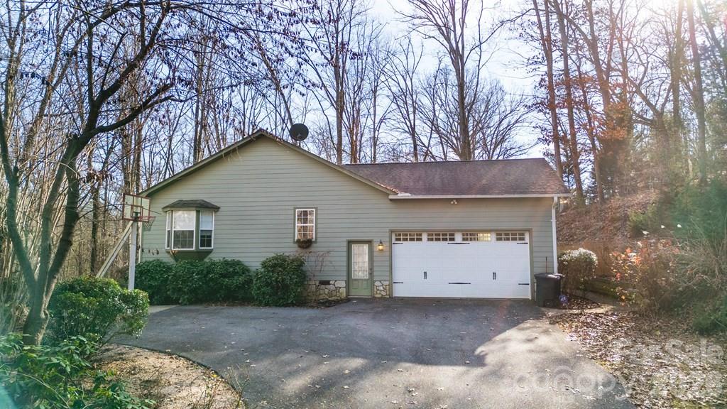 One-Level Living in the Heart of the Mountains! Conveniently located just minutes from both Sylva and Dillsboro, this beautifully designed 3-bedroom, 2-bath home offers the perfect blend of comfort and accessibility. Step inside to an open-concept great room featuring a dramatic tongue-and-groove cathedral ceiling and dormers that fill the space with natural light. The kitchen is a standout with stainless steel appliances, granite countertops, and custom cabinetry — all flowing seamlessly into the dining and living areas. A cozy gas log fireplace adds warmth and charm. The oversized main suite is a true retreat, complete with a spacious walk-in closet and a spa-like bath featuring a whirlpool tub with tiled custom accents, a shower, and beautiful tile flooring. French doors open to a large, private deck — perfect for relaxing or entertaining. Additional highlights include durable Hardiboard siding, a covered screened-in front porch, and an oversized two-car garage with dedicated workshop space. Easy paved access makes commuting a breeze. This one checks all the boxes — schedule your showing today!