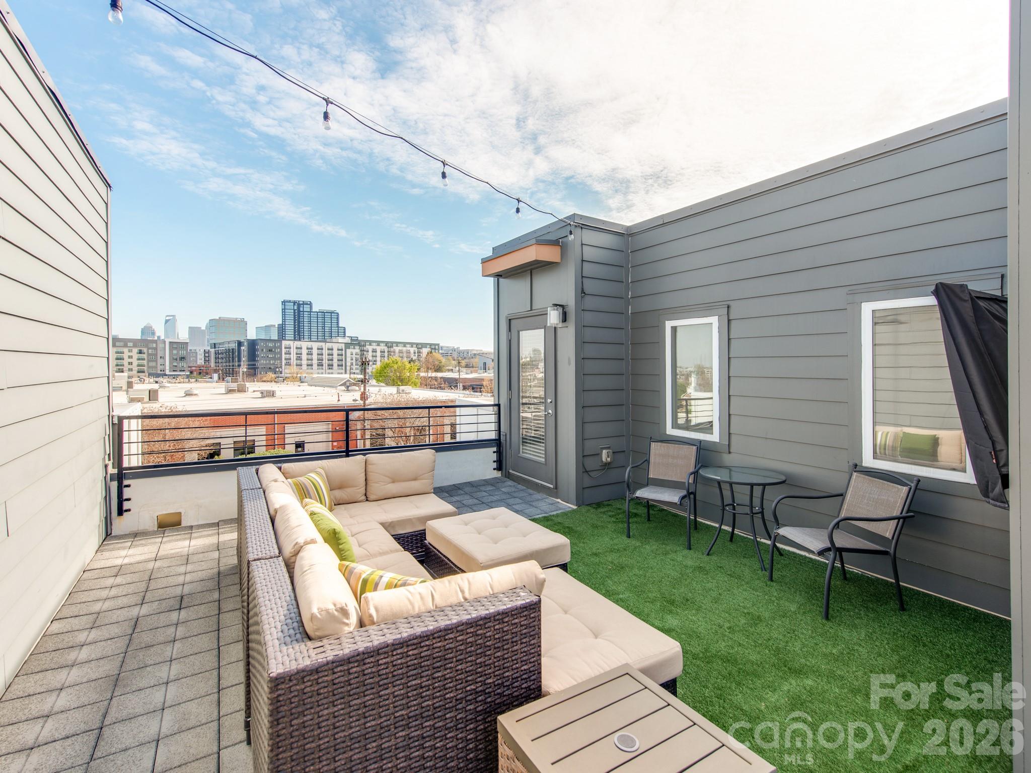 Experience the heart of SouthEnd in this stunning four-level modern townhome, offering easy access to some of SouthEnd's best breweries, restaurants, and the Rail Trail.  Boasting 3 bedrooms and 3.5 baths, this residence provides a rare city view opportunity. The ground floor features a spacious side-by-side, two-car garage with built-in cabinet storage, and a versatile guest suite with a full bath—ideal for a home office or gym.

The main level is an entertainer’s dream, featuring a seamless open floor plan and a chef-inspired kitchen equipped with premium KitchenAid stainless steel appliances. A custom bar and additional cabinetry provide the perfect kitchen extension for a coffee station or wine bar. Retreat to the third level to find a serene primary suite with a walk-in closet and extended bathroom countertop, alongside an additional bedroom and full bath. The crowning jewel? A massive fourth-floor rooftop terrace offering breathtaking, unobstructed views of the Uptown skyline—the ultimate backdrop for morning coffee or sunset cocktails.