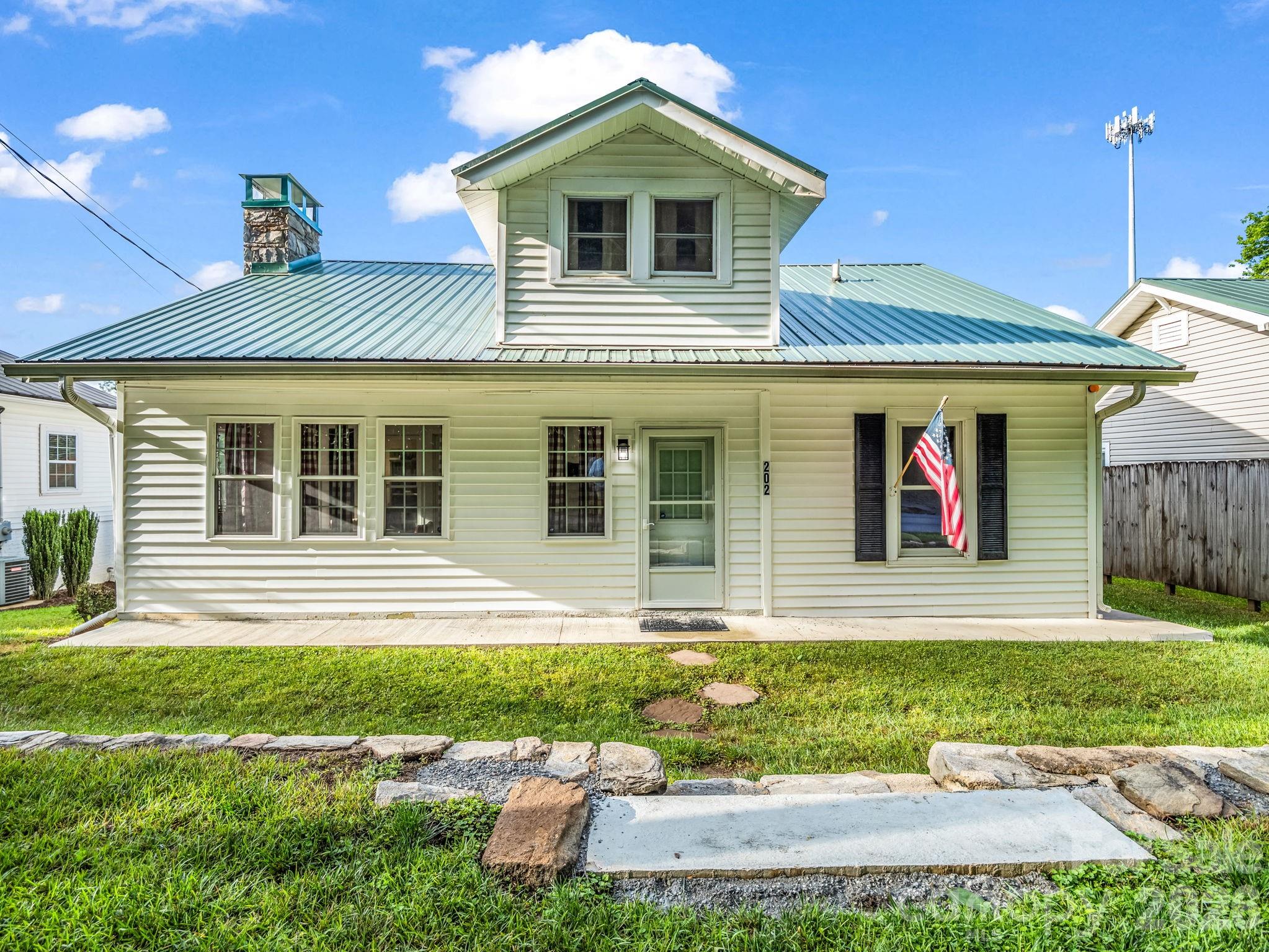 Welcome to your ultimate mountain-lake escape in the heart of downtown Lake Lure! With two bedrooms and one bath on the main level, this enchanting cottage perfectly blends nostalgic cabin vibes with modern conveniences, offering an unbeatable location and an effortless, turnkey lifestyle. A deeded easement to the lake access with ownership of the dock provides the perfect launchpad for peaceful days spent kayaking or canoeing. The interior boasts a stone gas fireplace, modern appliances, LVP flooring and an enclosed patio perfect for all seasons. Low-maintenance exteriors and adorable curb appeal make this perfect for a second home retreat or rental property. Offered turn-key! The upper level is below 7 feet, so not included in square footage, but it has two bonus rooms and a living room. The upstairs bath was added later and unpermitted. The property includes two parcels; the lot behind the home is where the septic is located and is in a flood zone, but the house is not.