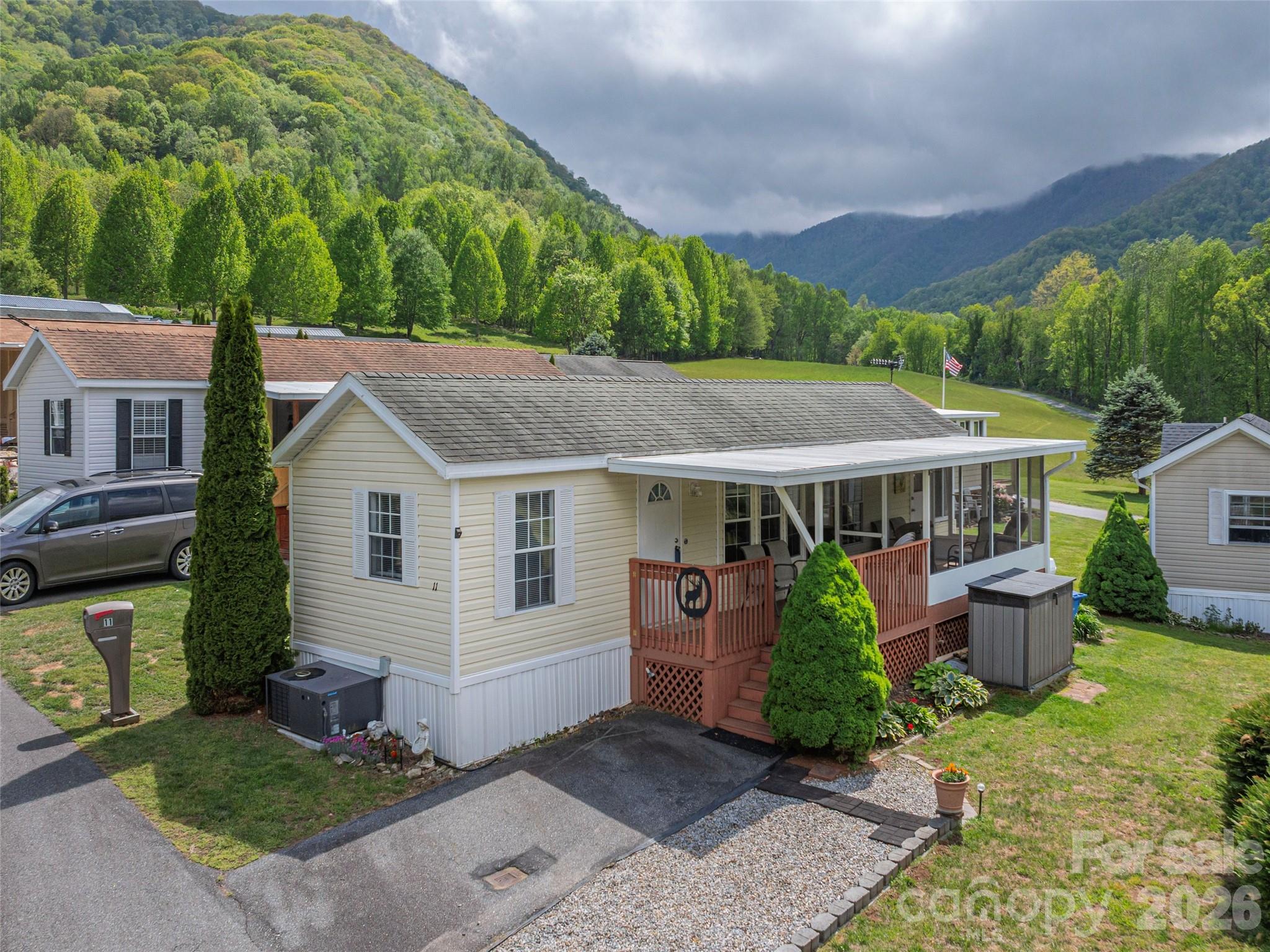 Nestled in the picturesque Maggie Valley, 11 Valentine Dr. is a stunning turnkey park model that embodies the essence of serene, simple living amidst nature’s beauty. Surrounded by the tranquil sights and sounds of the watershed, where elk gracefully graze and squirrels frolic, this charming retreat offers an inviting open floor plan adorned with cheerful paint, creating a warm and welcoming atmosphere. Enhancing its appeal are both a sunroom and a screened-in porch, providing ample bonus living space to soak in the breathtaking surroundings. Situated within a vibrant 50+ community, this delightful home is conveniently located near a variety of restaurants and entertainment options in Maggie Valley, Waynesville, and the scenic Blue Ridge Parkway, making it the perfect haven for both relaxation and adventure.