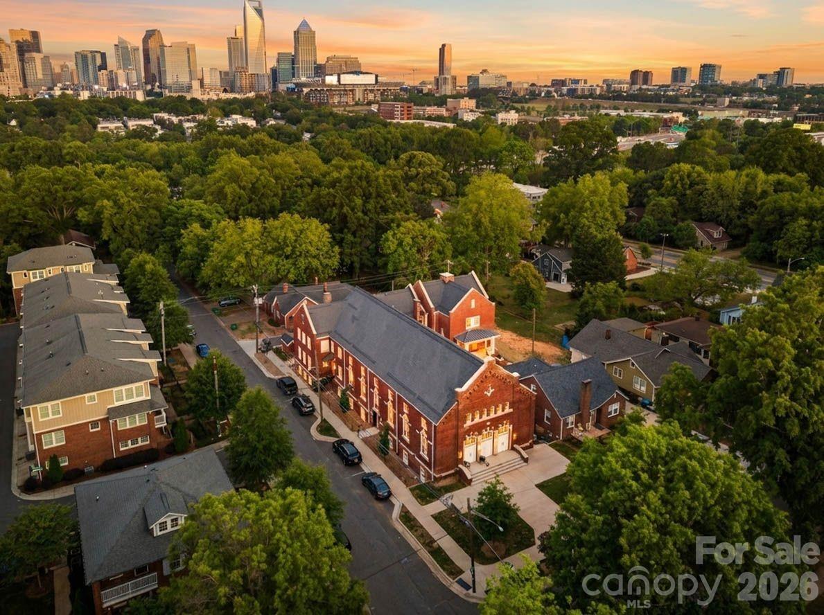 A rare opportunity to own a piece of Charlotte history — thoughtfully reimagined for modern, lock-and-leave living. Located within The Arches, a boutique collection of residences set inside a restored 1927 church in the heart of Wesley Heights, this luxury townhome-style condo offers a distinctive blend of historic architecture, modern functionality, and urban convenience. Originally built as a neighborhood church and place of gathering, the building has been carefully transformed while preserving its historic integrity, timeless presence, and architectural character. Each residence offers a private entrance, giving the home a sense of individuality and privacy rarely found in condo living. Inside, the main living area feels bright, open, and inviting, with warm wood flooring, fresh neutral interiors, recessed lighting, modern ceiling fans, and abundant natural light. The open-concept layout flows seamlessly from the living area into the kitchen, creating an easy everyday living and entertaining experience. The kitchen is beautifully appointed with white cabinetry, quartz countertops, stainless steel appliances, a tile backsplash, pendant lighting, and an oversized island with seating. Spa-inspired baths feature porcelain tile shower walls and floors, modern fixtures, and clean, elevated finishes. The private rooftop terrace is one of the home’s standout features, offering the perfect place to unwind, entertain, and take in Uptown Charlotte views and evening city lights. Additional highlights include deeded parking space available for purchase, thoughtful modern finishes throughout, and the unique character of a historic adaptive reuse property. Ideally located minutes from Uptown Charlotte, South End, I-77, greenway access, parks, breweries, coffee shops, restaurants, and neighborhood favorites throughout Wesley Heights, The Arches offers a rare blend of history, design, and lifestyle in one of Charlotte’s most connected urban neighborhoods.