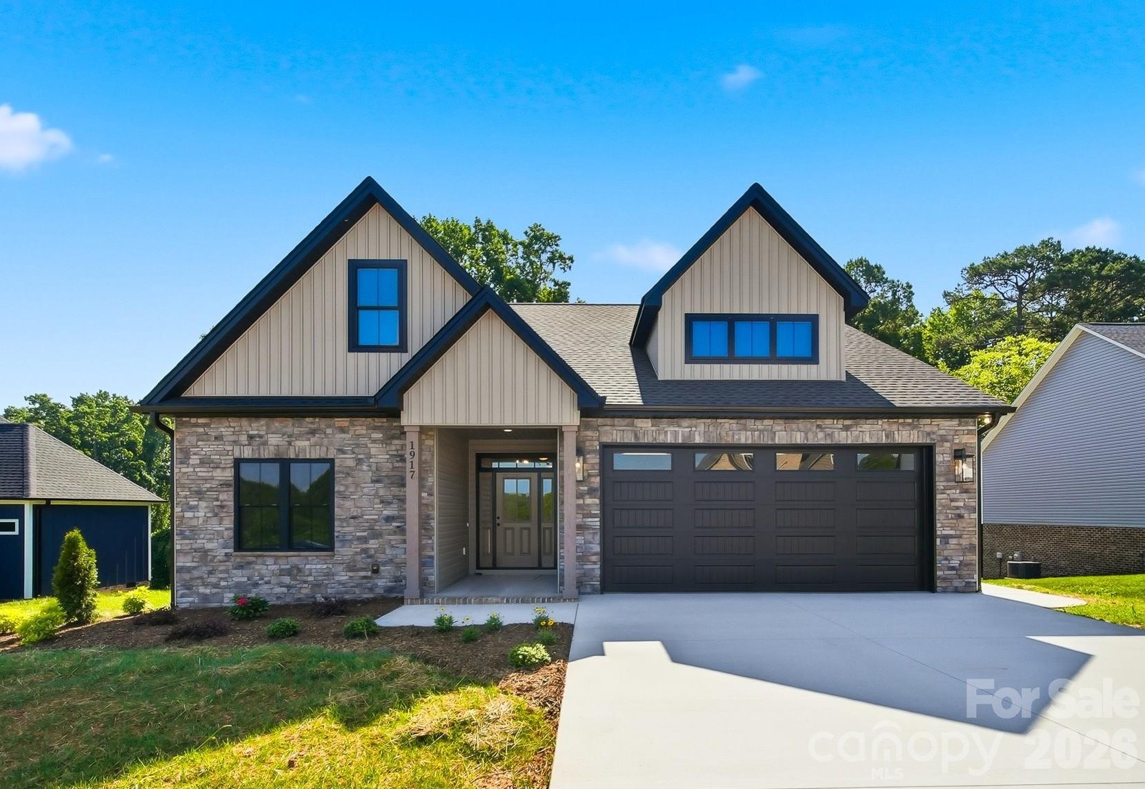 Beautiful new construction in Wallace’s View offering thoughtful design, quality finishes, and a convenient location near US-321, NC-127, and I-40 for an easy commute. The exterior showcases an attractive combination of stone and vinyl siding for timeless curb appeal. The inviting open-concept kitchen, dining, and living area features a gas log stone fireplace with custom millwork, creating a warm and stylish focal point. The kitchen offers abundant cabinetry, granite countertops, stainless steel appliances including a gas range, pantry, undercabinet lighting, and a tile backsplash.

The main-level primary ensuite features a tray ceiling, custom walk-in closet, and tiled step-in shower. Two additional bedrooms and a shared bath are also located on the main level, while the upper level offers a private fourth bedroom with ensuite bath and walk-in closet. LVP and tile flooring flow throughout the home. The laundry room includes cabinetry and a granite countertop. A convenient drop zone just off the two-car garage provides the perfect space for organizing everyday essentials.

Enjoy outdoor living from the covered back deck with ceiling fan and light, overlooking a wooded backdrop. Additional highlights include detailed millwork and lighting, a gas-powered tankless water heater, and gas furnace. A beautiful blend of comfort, style, and functionality in a newly constructed home! Monthly HOA fee includes Spectrum internet/TV.