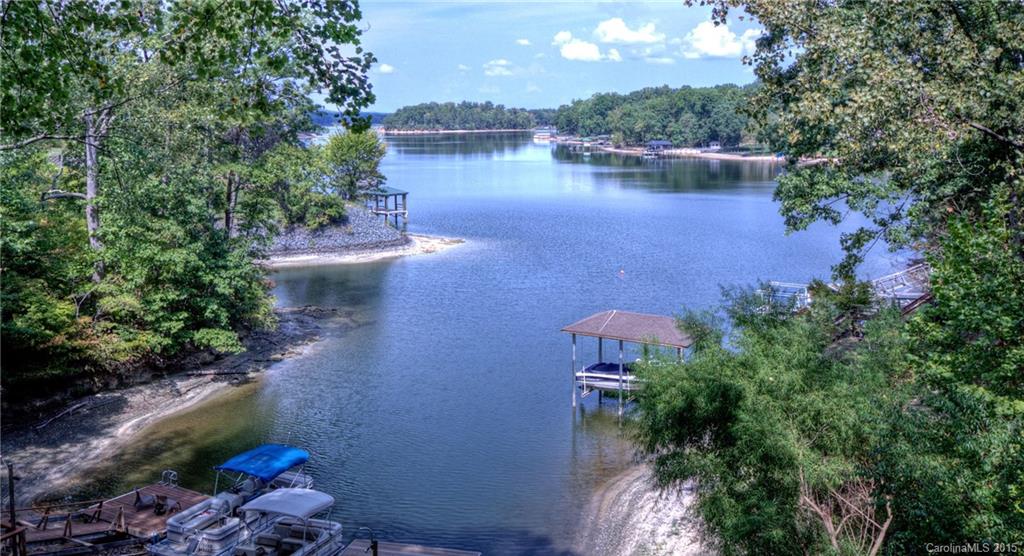 Tega Cay waterfront home with long range views, stretching towards the main channel of Lake Wylie! Four bedroom home with full finished basement, large living areas, rec room and office. Easy living floor plan with master plus two bedrooms on main level, 4th BR on lower. Cathedral ceiling in great room designed to accentuate the gorgeous view. Large deck and side patio, perfect for relaxing & entertaining. Double lot, low-maintenance natural landscaping. Dock w/ swim platform. Excellent schools!
