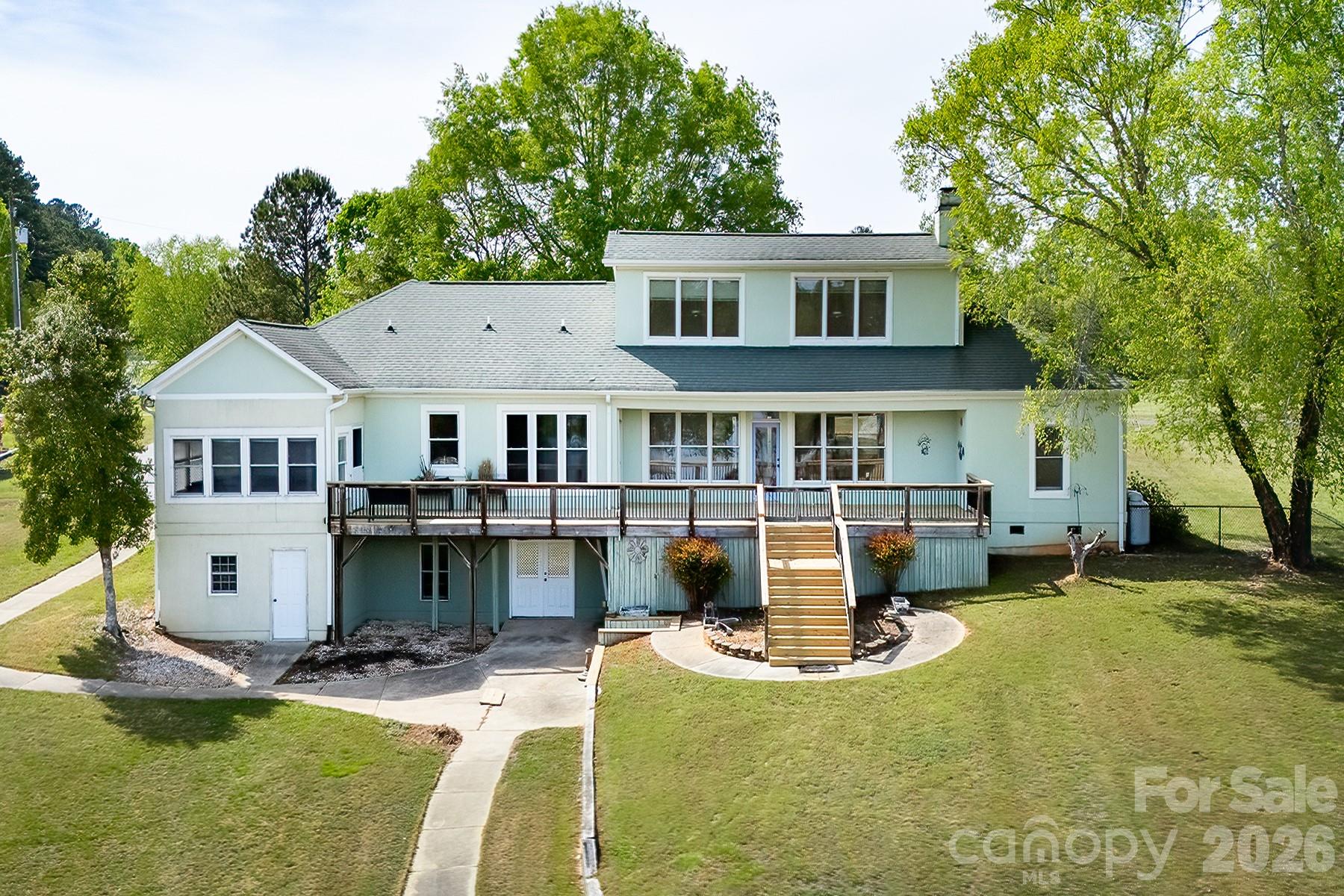 Peaceful lake living meets wide-open space at this contemporary retreat on Lake Tillery. Set on a flat, spacious lot that is just over an acre in a quiet rural setting, this property invites you to slow down and enjoy the beauty of the outdoors—from mornings on the water to evenings on the expansive back deck.

Offering generous space inside and out, this property provides the perfect canvas to reimagine and create your own lakefront retreat in a serene, natural setting.

Inside, the vaulted great room and dining area create a light-filled, open feel, offering a wonderful foundation for everyday living and entertaining. The split-bedroom layout provides added privacy. Step outside to take in the picturesque landscape, head down to your private one-slip boathouse for a day on the lake, then cozy up by the fireplace to unwind. Boathouse does have grandfathered status as it is over the property shoreline allocation lines.

The home features a large primary suite with walk-in closet, an oversized two-car garage, and an unfinished basement ideal for storage or future expansion. With a desirable layout and great potential, this property presents a wonderful opportunity to update and make it your own.

Ideally situated near Morrow Mountain State Park and Uwharrie National Forest for endless outdoor recreation, and within a short drive of the charming towns of Albemarle, Norwood, Badin, Mount Gilead, and Troy for dining and shopping. Lake Tillery features waterfront dining and multiple marinas, while major cities like Charlotte, Winston-Salem, Raleigh, Durham, Pinehurst, and Greensboro are all within an easy drive.