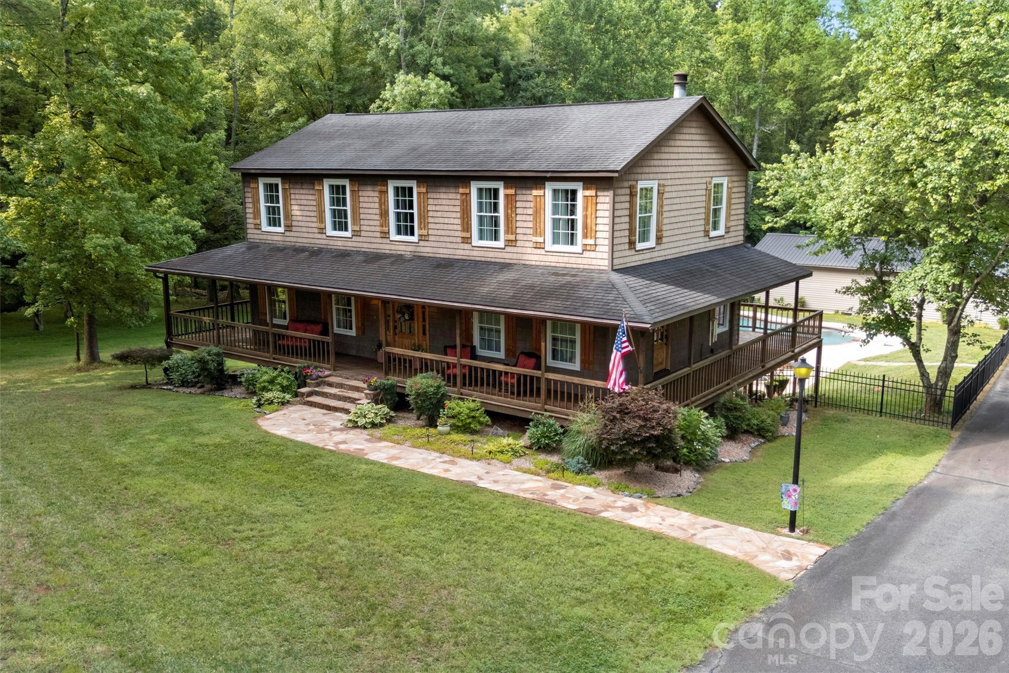 Rarely does a property in Mooresville offer this level of privacy, recreation, and workspace all in one package! Set on 10 secluded acres surrounded by mature trees and a creek, this amazing estate features a spacious 3-bedroom home, a finished walkout basement, a resort-style backyard with a pool, and an incredible 4,900+ square foot auto shop designed for serious enthusiasts or hobbyists. A welcoming wraparound porch leads into the kitchen showcasing granite countertops, stainless steel appliances, and abundant cabinetry while remaining open to the family room with a gas fireplace. The formal dining room provides additional entertaining space and adjoins an additional sitting room. Upstairs, the generously sized primary suite offers 2 closets and attached bathroom with double sinks, garden tub and shower. Even though the septic permit is only for 3 bedrooms, there is an additional flex room with a closet upstairs. Downstairs, the finished walkout basement expands the living space with a large recreation room, custom-built bar, full bath, and endless possibilities for entertaining, game nights, fitness, or media space. Outdoors, enjoy your own private retreat featuring a large deck overlooking the in-ground pool, patio, space for a hot tub and expansive yard surrounded by peaceful wooded views. You may commonly see deer or wild turkeys in the yard! The detached 4,986-square-foot auto shop is truly one of a kind! It's equipped with 200-amp electrical service, air compressor system, office, kitchenette break area, restroom, and loft, making it move-in ready for automotive hobbyists, collectors, or anyone needing an exceptional workspace or storage. There's ample space to store vehicles, campers, tractors and more! You feel secluded, but are still conveniently located just minutes from Downtown Mooresville, Lake Norman, Concord, Kannapolis, NC-3, and I-77. This truly amazing property combines country privacy with everyday convenience. Please DO NOT attempt to view home without appointment. Hawks Prey is a private drive. Home cannot be seen or accessed from road. Thank you!