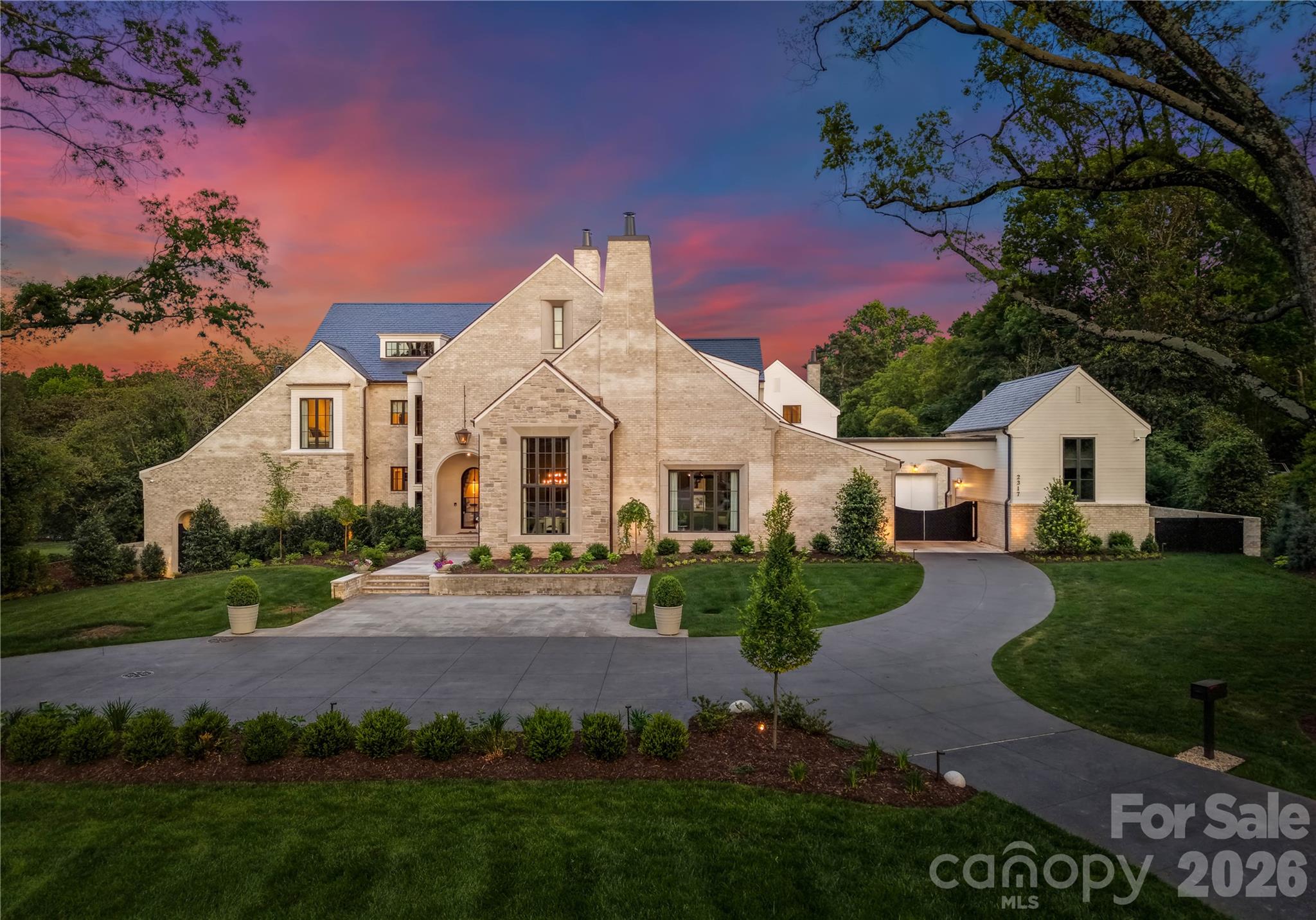 Welcome to this extraordinary custom estate in the heart of SouthPark, set on 1.3 private acres. Expertly built by Ted Thompson, with architecture by Bryan Merman and interiors by Amy Lee, this home pairs refined design with everyday livability. A light filled, open floor plan with soaring ceilings flows seamlessly indoors and out. The main level features a formal dining room, a fully equipped scullery, and a showpiece kitchen with dual islands and a glass-enclosed wine wall. The private primary suite offers a spa-like bath, expansive custom closet, and dedicated laundry. An attached secondary living quarters includes its own family room, full kitchen, laundry, guest suite, and bath, ideal for extended guests or multi-generational living. Designed for hosting guests, this home offers an  entertainers lounge with custom bar, golf simulator, and sliding glass doors opening to a resort-style, vanishing-edge pool. The lower level features a car collector’s dream garage with glass-enclosed car elevator, home theater, secure vault room for the curated collector, oversized gym, massage room, and full wellness suite with steam shower, sauna, and cold plunge. Outdoor living is equally impressive with a chef’s grilling station, covered terraces with heaters and fans, putting green, and expansive green space. With garage space for up to 18 cars, this property delivers a rare combination of scale, function, and elevated luxury.