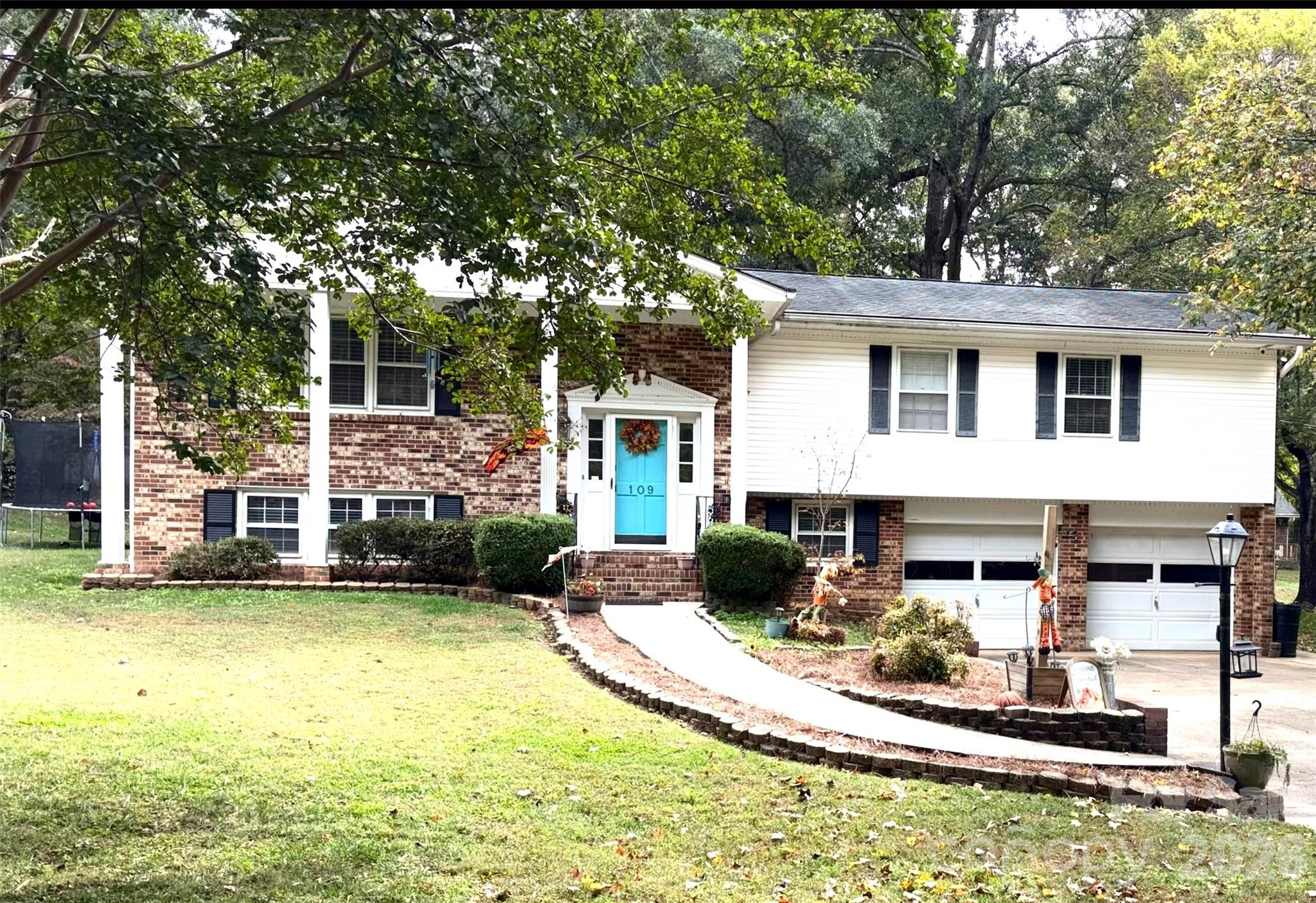 May qualify for 100% USDA financing (buyer to verify with lender)! Welcome home to this beautiful 3-bedroom, 2-bath split-level home situated on a private 1.33-acre lot in Dallas, NC. The inviting foyer features a split staircase leading to spacious main living areas designed for comfortable living and entertaining. The main level offers an open-concept layout with a large living room, dining area, wood flooring, and ceiling fans throughout. The kitchen includes stainless steel appliances, a large island, breakfast area, built-in desk, bay window, and an adjacent sunroom that is perfect for a home office or relaxing retreat.
The primary suite features a sitting area, two walk-in closets, and an en-suite bath with double vanity. The lower level provides additional living space with a large versatile room highlighted by a cozy fireplace, along with an additional bedroom, office, laundry area, and extra storage. Additional features include a tankless water heater and whole-home water filtration system.
Enjoy outdoor living on the large deck overlooking a private, park-like backyard with mature trees, greenhouse, and plenty of space for gardening or recreation. The property also includes a massive 1,500+ sa ft detached garage/workshop in addition to the attached two-car garage, offering exceptional space for vehicles, hobbies, or equipment. A rare opportunity to own a private retreat with space, comfort, and versatility.
