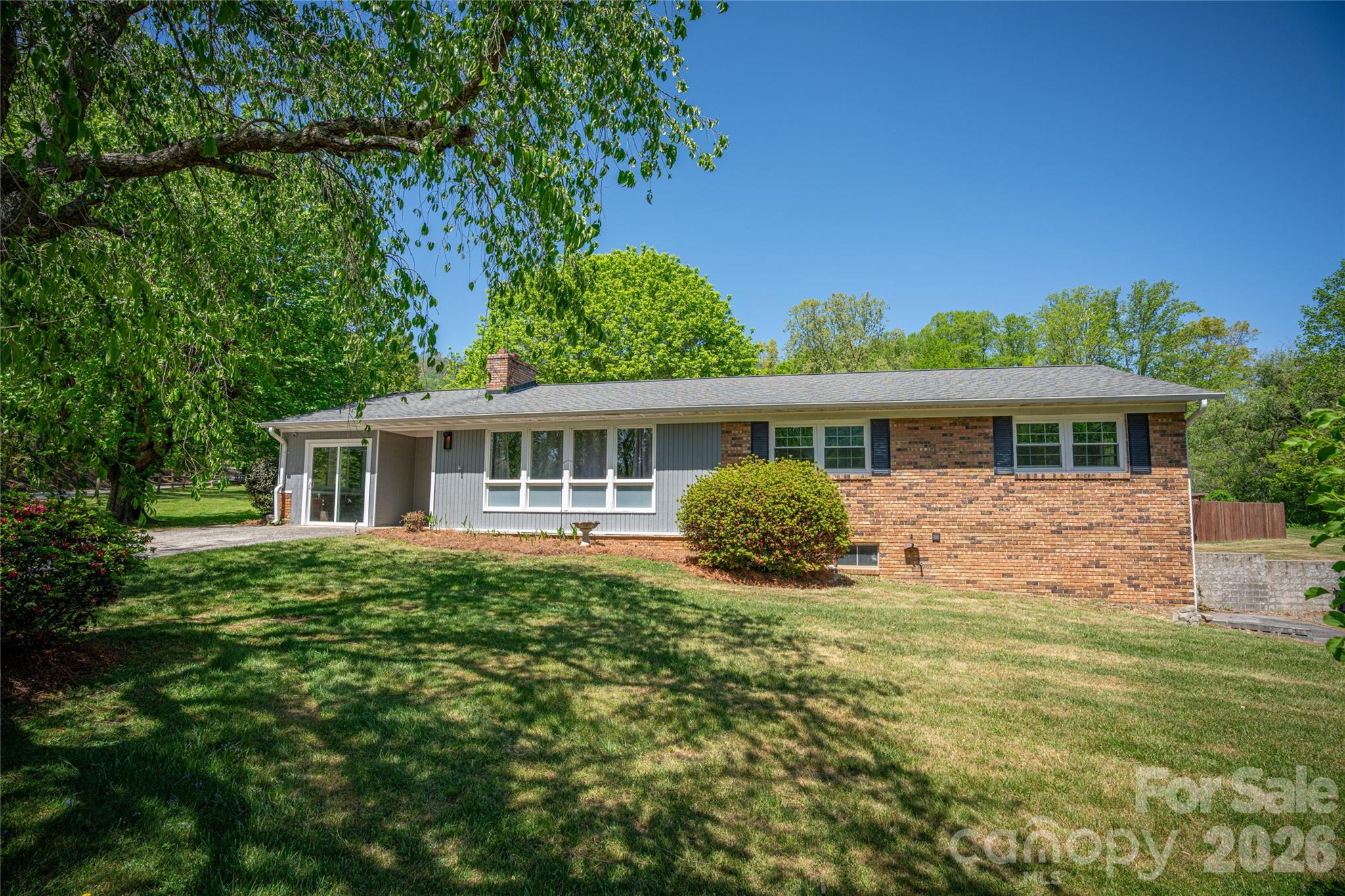 Surrounded by the natural beauty of Western North Carolina, this well-maintained brick home offers the space, setting, and flexibility you've been searching for. Situated on 1.44 scenic acres with a private pond and expansive backyard, the property provides a peaceful retreat while remaining just 15 minutes from downtown Asheville and minutes from the Blue Ridge Parkway and charming downtown Weaverville. Inside, you'll find 3 bedrooms, 3 full baths, hardwood floors, abundant natural light, and a spacious living room anchored by a cozy fireplace. The functional floor plan offers comfortable everyday living, while the permitted finished lower level adds valuable flex space that can easily serve as a recreation room, home office, fitness area, hobby room, or guest retreat. Step outside to the covered patio and enjoy the tranquil surroundings, where there's plenty of room to entertain, garden, or simply relax. A new HVAC system installed in 2026 provides added comfort and peace of mind. Combining privacy, convenience, and versatile living space, this property offers the best of both worlds—quiet country living with easy access to restaurants, shopping, and outdoor adventures throughout Weaverville and Asheville.