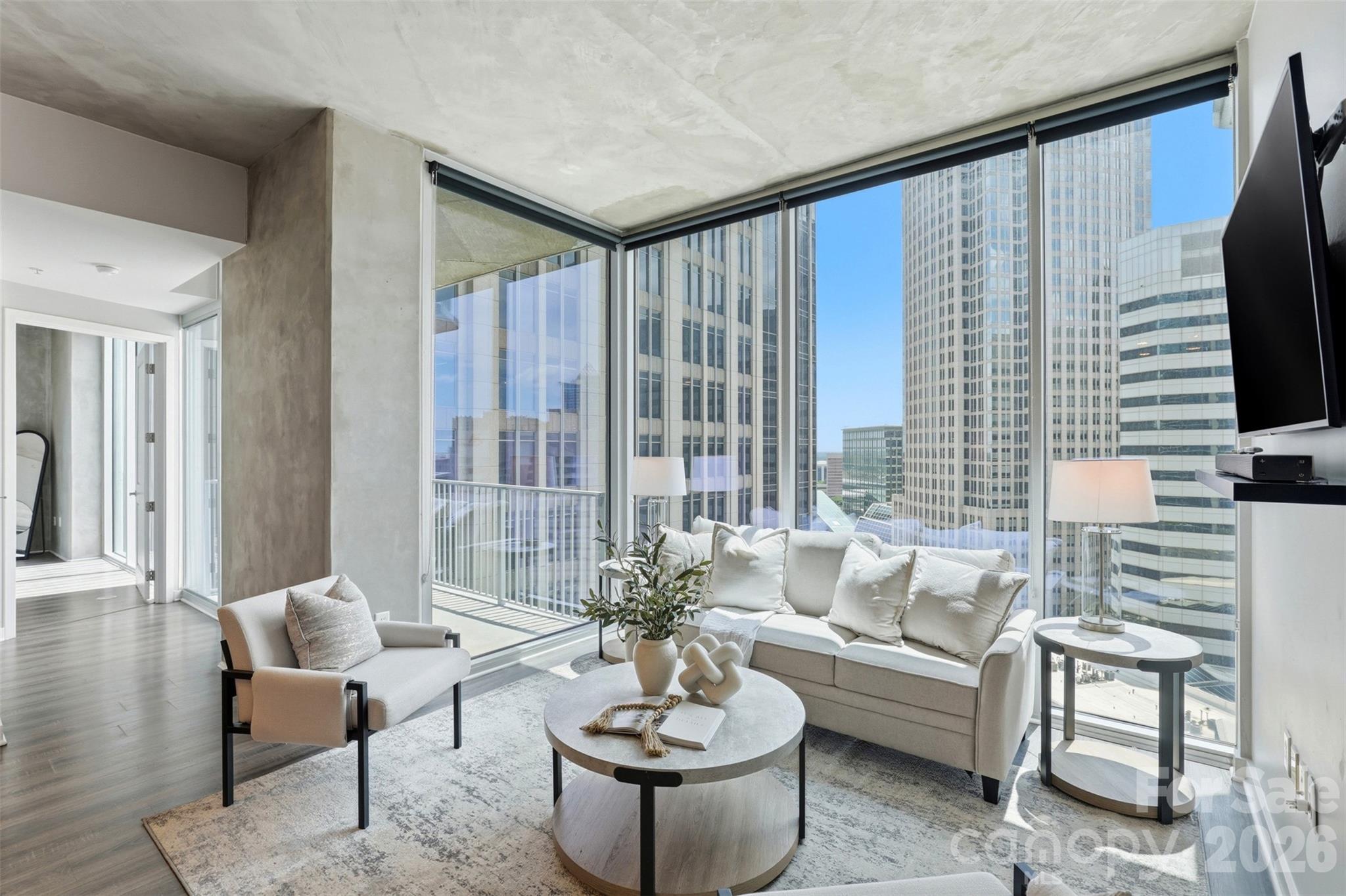 Uptown Living At Its Best! This 18th floor unit at Avenue Condominiums offers an elevated urban living experience in the heart of Uptown Charlotte. This condo is thoughtfully designed from top to bottom with a clean, modern aesthetic and expansive floor-to-ceiling windows that provide sweeping panoramic skyline views and abundant natural light. The open-concept living and dining areas are ideal for entertaining, complemented by a private, tucked-in balcony positioned for vibrant city sunsets. The turn-key Kitchen features new stainless steel appliances, including fridge, range, dishwasher, microwave & wine cooler. The primary suite serves as a serene retreat with a custom closet, an ensuite bath, and spectacular views of the Charlotte skyline. Additionally, a flexible second bedroom can easily serve as a guest suite or home office. Key features include: Two designated parking spaces on P3 (561 and 562); Google Fiber included in HOA dues; and Incredible Building Amenities: 24-hour concierge in stunning lobby, resort-style pool, fitness center, SkyLounge, business center and more.