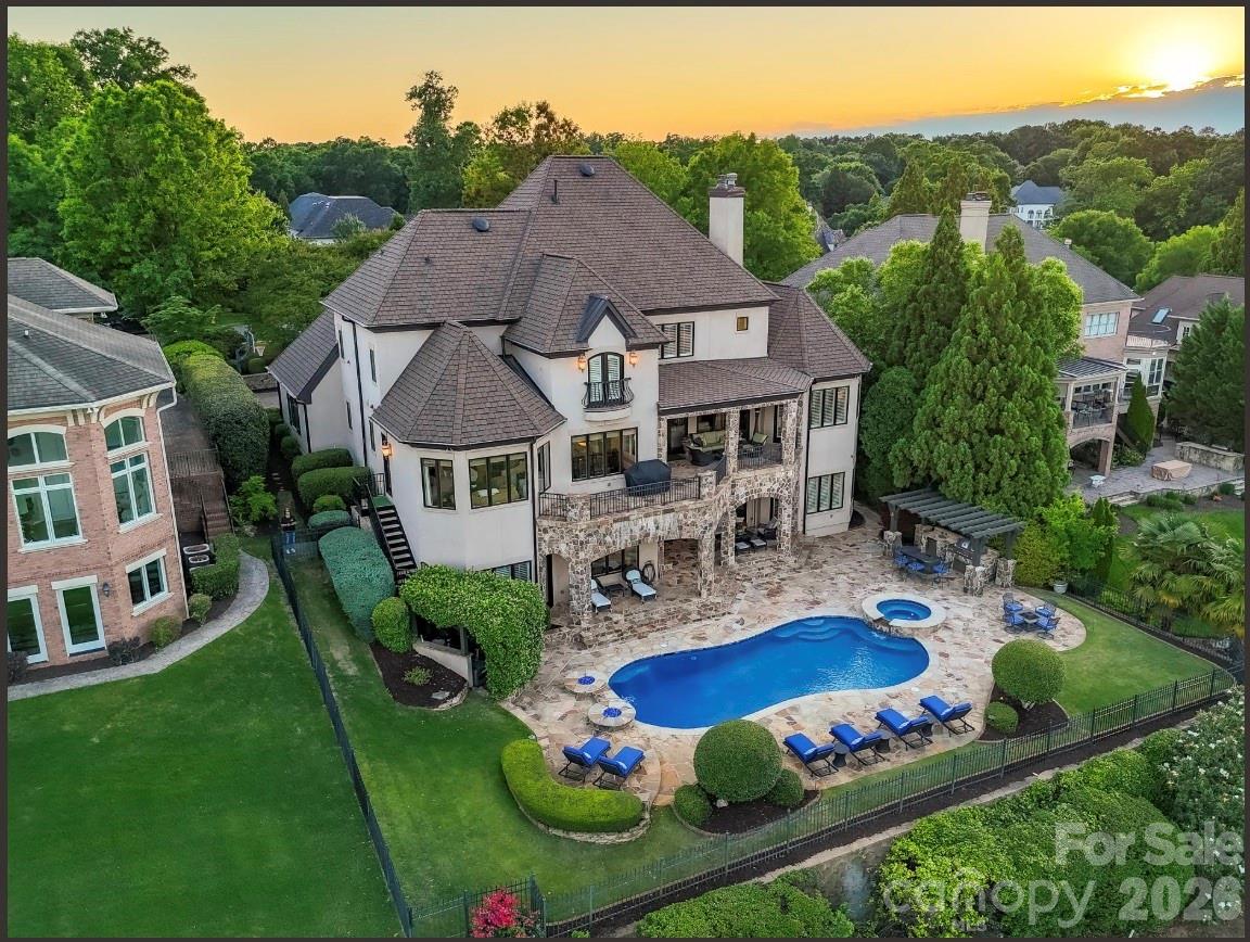 Set along the 11th fairway in Ballantyne Country Club, this extraordinary estate is a masterclass in timeless luxury, architectural elegance, and resort-style living. Tucked behind a dramatic tree-lined paver drive, and manicured lawn, the residence immediately captivates with its commanding presence and breathtaking golf course views from all three levels.
Designed for both grand-scale entertaining and refined everyday living, this remarkable home offers six bedrooms, seven full baths, and two half baths with meticulously curated details throughout. A soaring two-story foyer welcomes you inside, where a sweeping curved staircase sets the tone for the sophistication that unfolds beyond. Just off the entry, a richly appointed office with vaulted wood accented ceiling and fireplace creates an inspiring retreat, while the elegant dining room with coffered ceiling flows to a butler’s pantry complete with a Sub-Zero wine refrigerator.
At the heart of the home, the gourmet kitchen is both stunning and functional, featuring an oversized island with microwave and warming drawer. A 6 burner Wolf gas range with custom hood, d/w, walk-in pantry and SubZero refrigerator, complete the kitchen.  The adjoining breakfast area and keeping room are bathed in natural light, highlighted by a striking tongue-and-groove wood ceiling and panoramic fairway views from every window. The grand great room showcases a coffered ceiling, custom built-ins, and a gas fireplace, with direct access to the expansive upper terrace overlooking the resort-inspired grounds.
The terrace spans across the back of the main level, offering a seamless indoor-outdoor lifestyle with tranquil golf course views.  The perfect place to relax. Below, the spectacular outdoor living experience continues with a saltwater pool and spa, cascading water feature, dual fire bowls, outdoor fireplace, flagstone patio, and outdoor kitchen. A dedicated pool bath with shower enhances the convenience of outdoor living..
The main-level primary suite is a private sanctuary designed with exceptional detail, featuring a vaulted wood-accented ceiling with cove lighting and fireplace. Luxurious spa bath with heated floors, separate vanities, Jacuzzi tub, oversized shower with pebble stone flooring, and dual custom closets. Additional main-level highlights include an oversized laundry room with extensive cabinetry and sink, two powder rooms, a drop zone with built-in desk area, elevator access to all three levels, and entry to one of two 2 car garages. Second 2 car garage access is near the front door/office with covered side entry 
Upstairs, three spacious guest suites each offer ensuite baths, including one with a Juliet balcony overlooking the golf course and another designed to function beautifully as an additional primary suite. A large bonus room with closet and an additional laundry room complete the upper level.
The walkout lower level was thoughtfully designed for unforgettable entertaining and multi-generational living. A dramatic curved staircase leads to a wine room with iron doors, full-size Sub-Zero wine refrigerator, wine storage and an accent window opening to the kitchen/entertaining area. The expansive family room features a stone fireplace, custom built-ins, and a full secondary kitchen, creating endless possibilities for hosting. This level also includes a billiards and game area, flex/bonus room, two additional bedrooms (one currently being used as a gym), two full baths, and a laundry hookup. 
This is more than a home, it is one of the most prestigious offerings in Ballantyne Country Club, where exceptional craftsmanship, timeless architecture, breathtaking scenery, and resort inspired living come together in one unforgettable estate. Welcome Home!
Club amenities require membership
