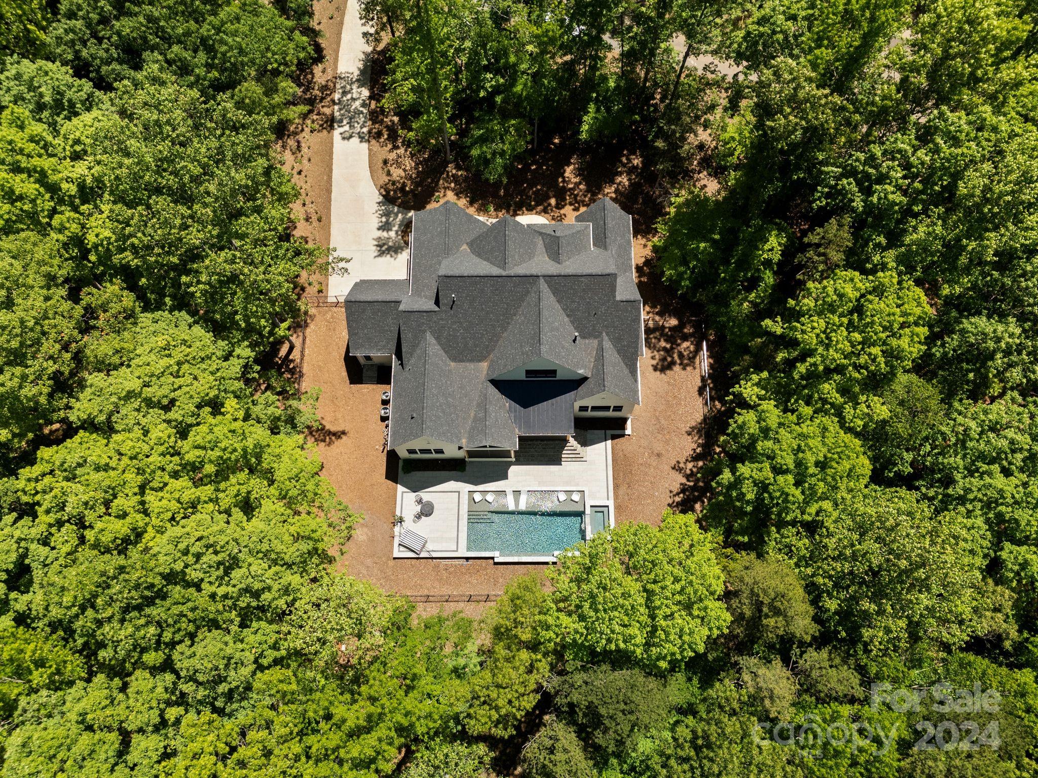 Welcome to your private retreat in the well-sought area of Davidson, NC. This property is privately situated on 3.5 acres in Maple Grove, a cluster of 6 estate sized lots and luxury homes. This pristine property has been thoughtfully designed with no expense spared. Features include uniquely designed ceilings, herringbone flooring patterns, exquisite lighting, oversized scullery, imported handmade Italian tile throughout. Kitchen features natural Vancouver Quartzite, 2 separate convection ovens with 6 burner range, hearth oven, spacious kitchen island. Primary suite on main with luxury bath and 2 walk-in closets. Second suite and office on main. Your statement staircase leads you upstairs to your library, media room and additional bedrooms. Veranda with retractable screen and outdoor kitchen overlook your luxury pool and serene setting. This lot site is unique as it touches Fisher Farm Park and has direct access to hiking/biking trails and Davidson Greenway. Truly a unique opportunity.