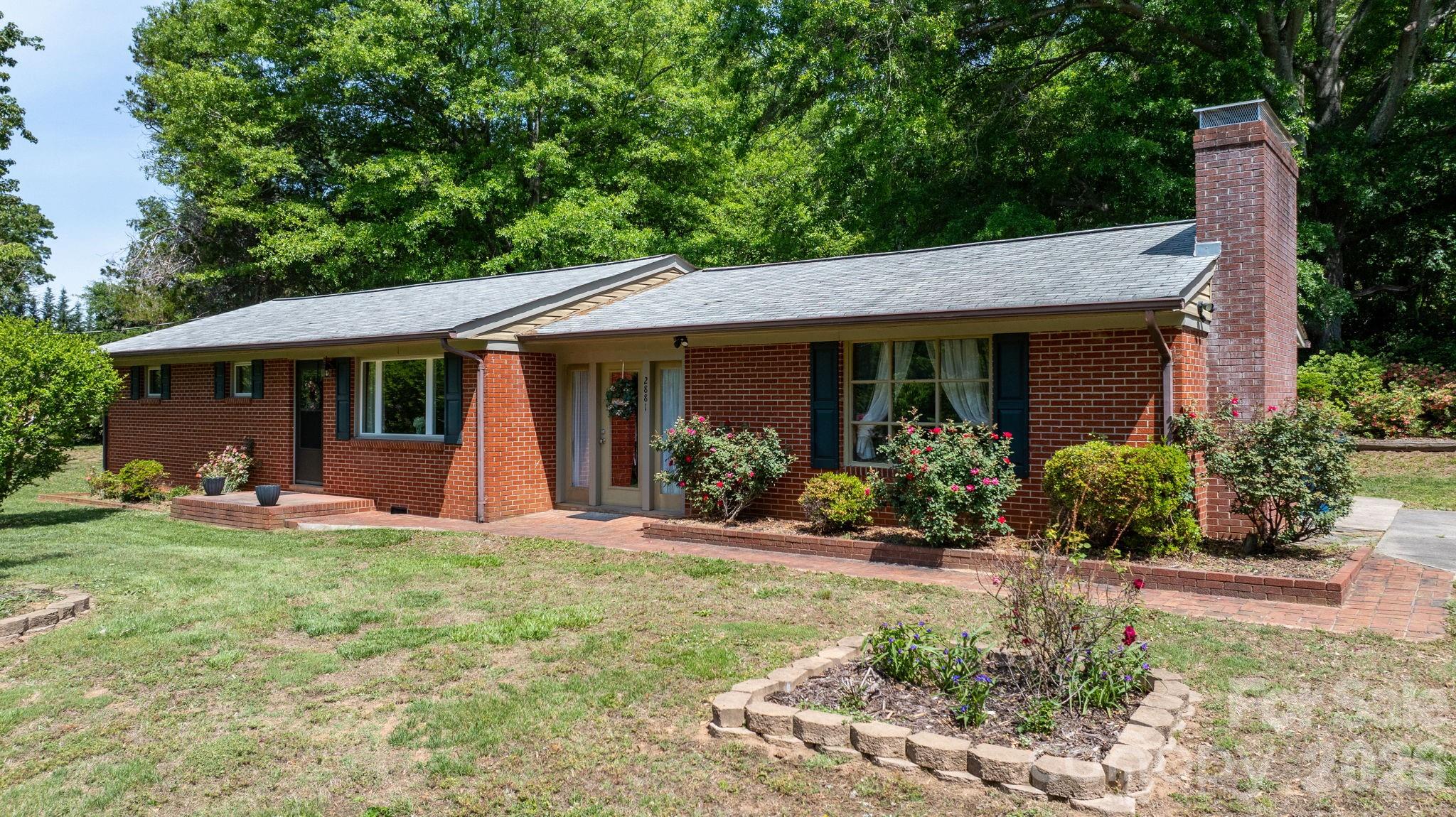 Located in charming Valdese, this well maintained one level home sits on one full acre! This home offers two living areas, a laundry room with ample storage, three bedrooms, and two full bathrooms. Enjoy time on your covered back patio or spend time tending to the flowers in your yard. Enter through the front door to a sunroom flanked on both sides by living areas. The full sized den has a wood burning fireplace and lots of natural light! Tucked behind the den in a full bathroom and laundry room. The other wing of this home hosts three full sized bedrooms and another full bathroom. This home is located between Morganton and Hickory. Hike and bike or shop and dine - this home is in a prime location to access all the foothills of Western North Carolina has to offer.