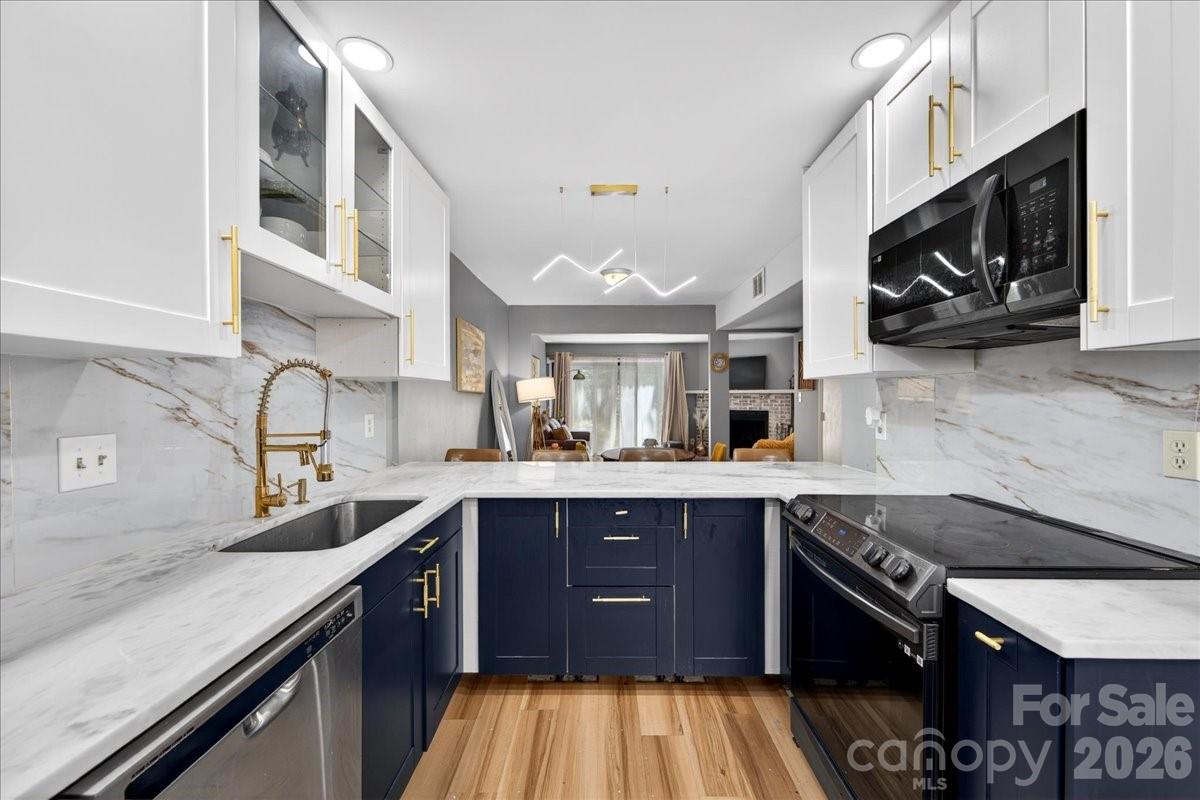 This turnkey home truly has it all- starting with an unbeatable location.  Enjoy the convenience of walking to nearby shopping and dining, all while being tucked into the desirable Raintree ne  neighborhood.  Step inside to find seamless, easy care LVP flooring throughout- no carpet anywhere.  The kitchen is the standout feature, showcasing crisp white upper cabinets paired with striking blue lower cabinets for a modern, designer feel.  Newer appliances including a sleek black oven and microwave, compliment this beautiful space.  Gorgeous quartz countertops and gold toned accents tie everything together, creating a kitchen that's as functional as it is eye catching.  The open floor plan allows a easy flow from the kitchen into the dining room and into the spacious great room- perfect for everyday living and entertaining.  The great room is anchored by a charming whitewashed brick fireplace with a white mantel.  French doors lead out to a private patio.  The primary bedroom is located upstairs and offers exceptional storage, boasting a WIC along with 2 additional closets.  The bathroom has been thoughtfully remodeled with stylish, designed finishes, creating a comfortable retreat.  The HOA fees cover lawn maintenance, parking area maintenance and water/sewer.  This property qualifies for a waived Raintree Country Club initiation fee of $30,000.