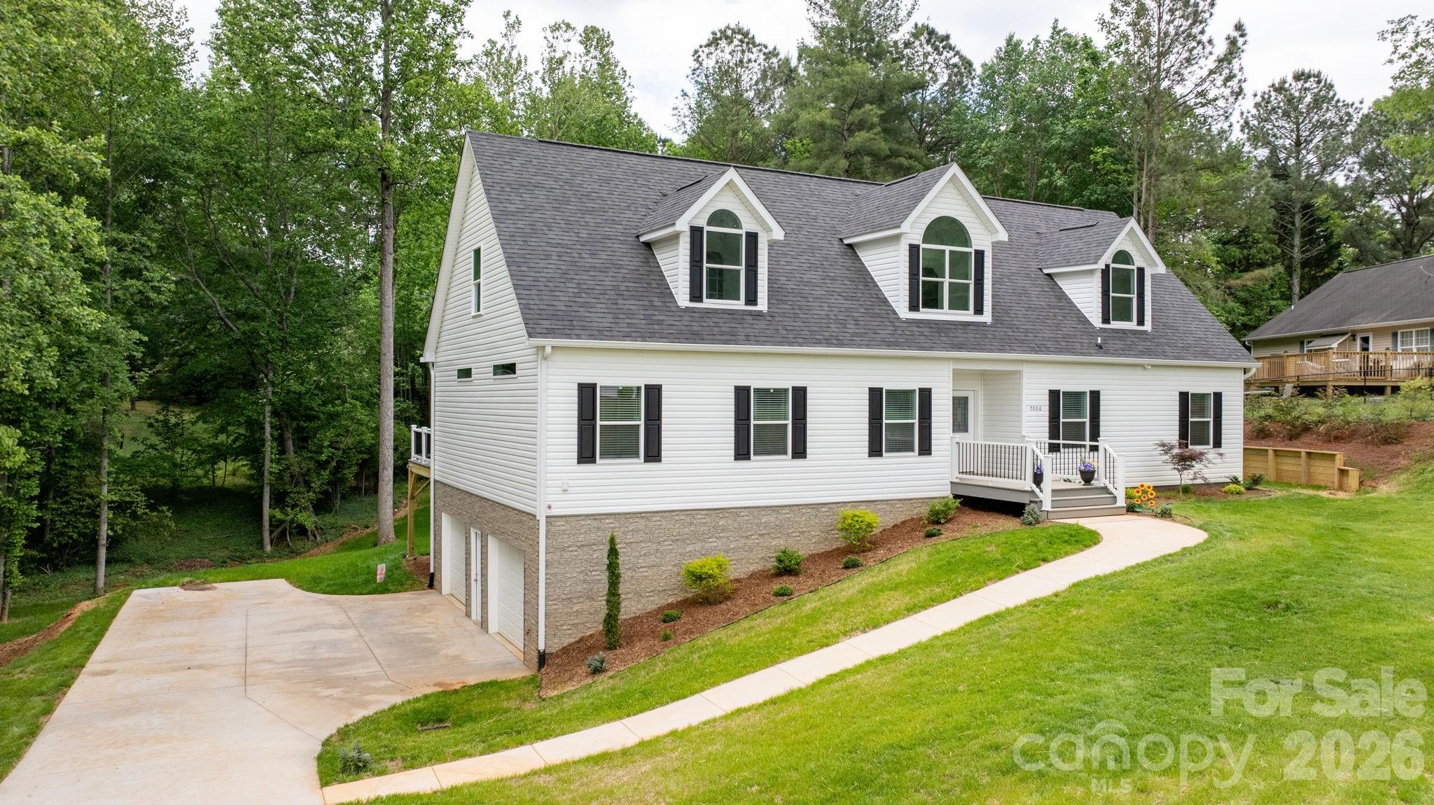 Step into your own private retreat with this meticulously crafted, newly constructed home in a pleasant subdivision on a quiet cul-de-sac near Lake Hickory.  The ‘WOW-factor’ begins when you step through the door into the spacious Great Room and Kitchen.  This luxurious Cape Cod features easy living, with a stunning HUGE back deck overlooking a wooded forest on a .79 acre lot. The Kitchen and Dining Nook feature a large island with a farmhouse double sink, flat-top stove and oven, walk-in pantry with automatic lighting, numerous cabinets, appliance garages, comfort-height microwave, and beverage/wine cooler.  The Great Living Area is enhanced by the gentle ambience of the LED recessed electric fireplace. This ‘Living-Made-Easy’ area steps into the expansive resort-like back deck and verdant backyard. The primary Private Suite designed bedroom and bath highlights include walk-in tile shower with dual shower heads (rain, regular, and hand-held) and comfort bamboo seat, double vanities, and an expansive, walk-in closet.  The all-important Laundry & Utility room is conveniently located around the corner from the spacious kitchen, with access to the restful back deck. The dedicated study on the main floor is perfect for a home office.  Two spacious bedrooms with large closets are on the opposite side of the house near the hall bathroom. The incredible 2nd-story is ideal for a ‘Pent-House Executive Office’, a media room, exercise and hobby room, or just a private place for relaxation and rejuvenation.  This additional living area boasts a 3rd complete bathroom. Leading from the Great Living Area to the lower level is an expansive, 2 car garage with extensive rooms for storage, workbenches, hobbies, woodworking, as well for mowers, water-craft and motorcycles, etc. The landscaping has been designed by a well-known local nursery and design company. Enjoy the beautiful photos of this magnificent, well-constructed house, ready to be made into your lovely home.