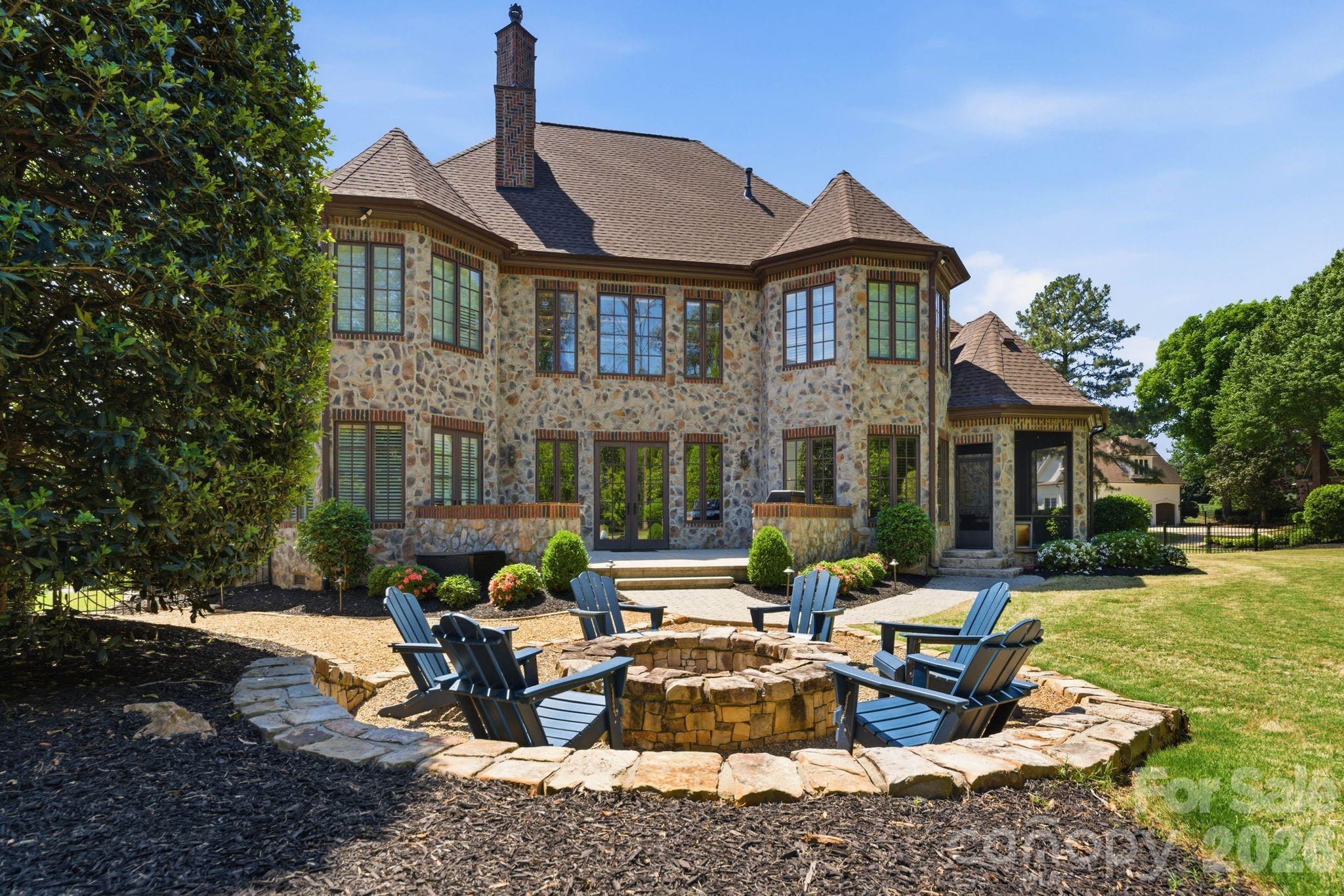 This 5,906 sq ft French Provincial masterpiece on .53 acres blends timeless European architecture with modern living, shown by the full stone and brick construction, architectural turrets with copper roofing, custom Clark Hall French doors, and three-car garage with cedar doors. 
The two-story foyer with grand spiral staircase opens to a soaring great room filled with natural light anchored by rich architectural detail, and floor-to-ceiling brick fireplace. The formal dining room features inlay hardwood flooring and a tray ceiling, offering an elegant setting for gatherings.
The chef’s kitchen is a showpiece of quality and design, centered around an oversized island wrapped in Walker Zanger Taj Mahal quartzite. A full-height backsplash, Brizo pot filler, a full suite of top-tier Wolf appliances, and ample counter space make everyday cooking and large-scale entertaining effortless. Spacious walk-in pantry with custom shelving completes the space, and a charming wet bar with hand-painted tile and beverage refrigerator elevates the flow for hosting.
The main-level primary suite provides a serene retreat with a spa-like bathroom, freestanding tub, separate dual vanities, and custom closets.
Upstairs, a spacious billiards/bonus room with painted wood beams and a full bar becomes an instant gathering space. The billiards table conveys, making the room completely ready for use on day one. There are three additional bedrooms all complete with spacious walk-in closets and ensuite bathrooms ensuring comfort and privacy for family and guests. Finally the flex room which could be used as a playroom, personal gym, sitting nook, or library. 
Outside, the private, fenced backyard offers a peaceful escape with mature landscaping, screened-in porch, a stone patio plumbed for a built-in grill, and a large stone fire pit with seating for many—an ideal setting for year-round outdoor living. Spacious garage with epoxy floor has keyless entry in two locations, Atom Power 11.5kw EV charger, custom shelving with a workbench, sink/faucet, wall organization, and an additional storage area with built-in cabinets to make seasonal storage easy.
Recent improvements include: • 30-year architectural roof (2022) • Mini-split HVAC for bonus room (2021) • Two additional HVAC units (2016) • Navien tankless water heater (2024) • Atom Power 11.5 kW EV charger (2024) • Complete interior improvements in 2022.