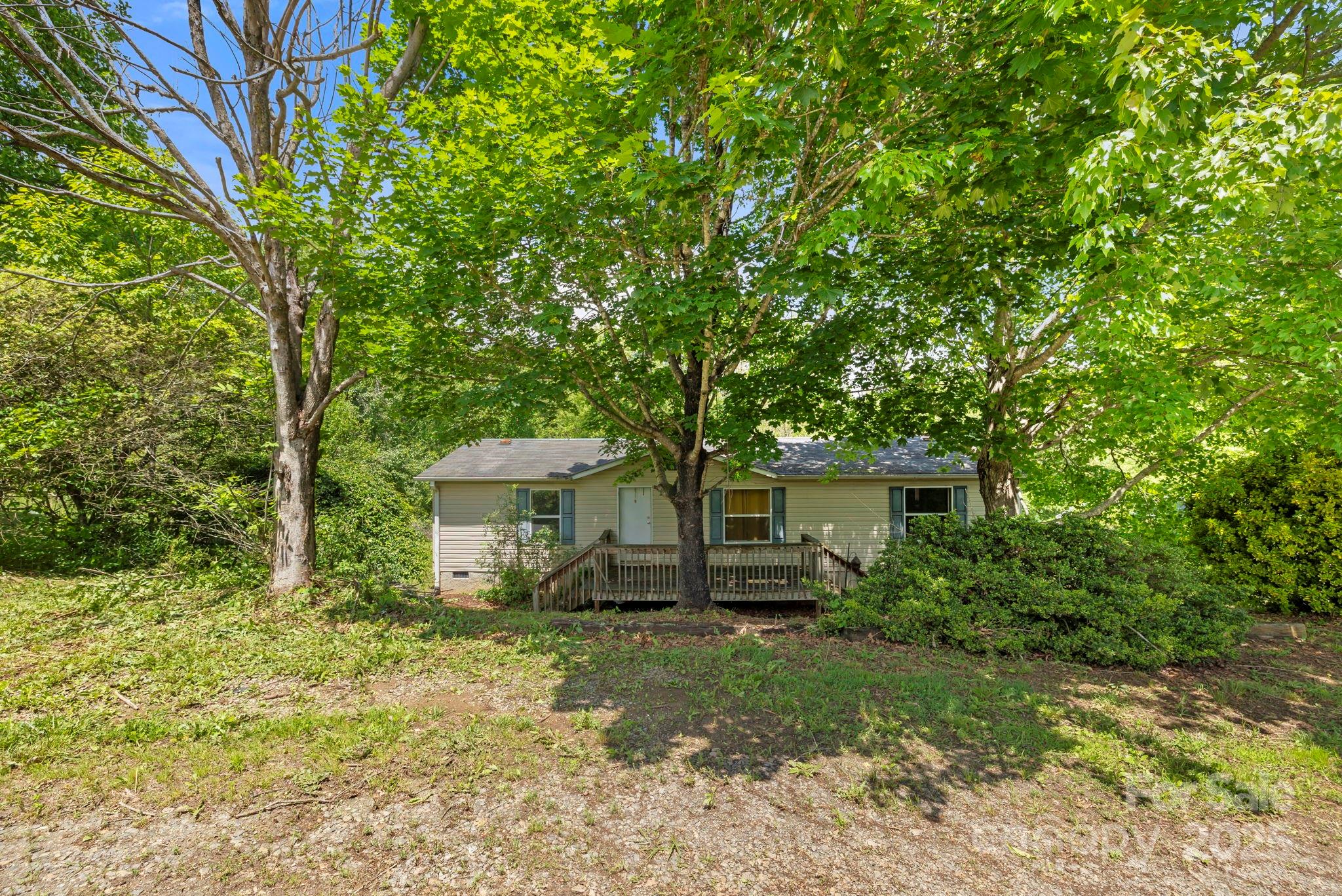 Charming home on just under ½ acre, perfect for an investment property or a peaceful getaway from the hustle and bustle of Asheville. Inside, you'll find a spacious open area that includes the living room, dining area, and kitchen. The roomy living room features a wood-burning fireplace, making it ideal for cozy evenings by the fire. The split floor plan ensures privacy while providing plenty of space for family or friends. The oversized primary bedroom includes its own en-suite bathroom, complete with a garden tub and a separate shower. On the other side of the house, there are two additional bedrooms that share another full bathroom. The kitchen comes equipped with all appliances and is conveniently accessible from the rest of the home. Step outside to enjoy the mature landscaping, which offers plenty of shade. Located in the Leicester community, this home is just 20 minutes from downtown Asheville.