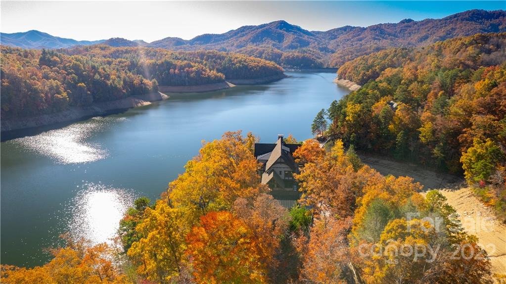Enjoy Lake Life at its best on your own private peninsula! This exquisite, hand crafted estate boasts timeless style & grace with cathedral grandeur being both luxurious & welcoming. From floor plan to interior design to the exterior spaces, nothing has been overlooked in design & construction. You'll be immediately drawn to the seamless blend of stone, wood and wrought iron echoed throughout generous indoor & outdoor living spaces. The main level features the great room walking out to multi-level terraces that beckon an indoor/outdoor lifestyle on Fontana Lake bordered by the Great Smoky Mtns Nat'l Park & Nat'l Forest. Double Thermador gas stove/oven, double Sub-Zero refrigerators & 2 islands. Dining Room, Breakfast Room & Breakfast Bar.  The main house features five suites with 2 add'l bedrooms in the guest apartment. Double boat house, media & game rooms, gym, hot tub, elevator, generator & dramatic sunset views make this the perfect estate to host family & friends.