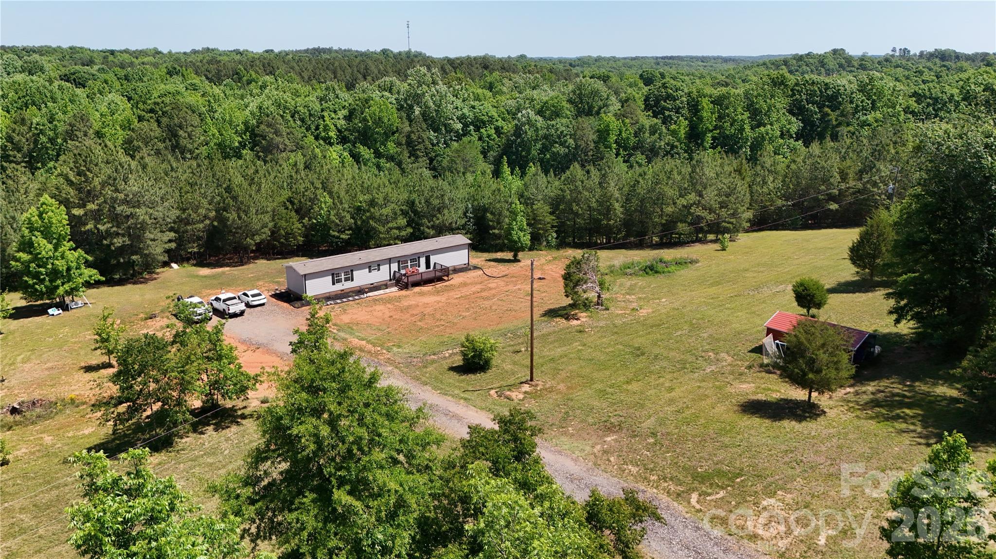 Located in the growing Roebuck community of Spartanburg County, this versatile 28± acre property offers you privacy, recreational appeal, as well as future investment potential. With two separate points of access, three individual parcels, and an excellent location just minutes from Spartanburg, this property is well-suited for buyers searching for a private estate, hunting retreat, family compound, or residential development opportunity in Upstate South Carolina.

This property is being sold with a well-maintained manufactured home that was purchased new in 2022. The home is situated on the northernmost parcel and features a gated entrance, providing privacy and controlled access from the road. The residence offers modern comfort and convenience while allowing the next owner the flexibility to enjoy the property immediately while continuing to improve the land for future use.

Several storage structures are already in place throughout the property, offering valuable space for equipment, tools, recreational gear, or workshop needs. One of the most unique features included with the sale is a set of eight custom-built hunting dog kennels. These kennels create an excellent setup for hunting enthusiasts, sporting dog owners, breeders, or outdoor recreation-focused buyers looking for a turnkey property with existing infrastructure already established.

The land itself offers a diverse blend of usability and beauty. A sizable creek winds through the property, adding scenic character as well as investment value to potential developers. The creek corridor creates an attractive natural setting for wildlife and provides the type of landscape feature many buyers seek when searching for acreage in Spartanburg County. The combination of open areas, wooded sections, and water resources gives the property excellent potential for hunting, trail riding, outdoor recreation, or simply enjoying a quiet rural lifestyle close to town.

From an investment standpoint, the property presents compelling possibilities. With approximately 28 acres divided among three parcels and dual access points already established, a developer or builder may see strong potential for subdivision and resale opportunities. Roebuck and the greater Spartanburg area continue to experience residential growth and increasing demand for homesites with acreage and privacy. The layout and accessibility of this tract may allow a future owner to enhance the property, improve infrastructure, and capitalize on the growing Upstate South Carolina real estate market.

Despite its private feel, the property remains conveniently located near Spartanburg, offering easy access to shopping, dining, employment centers, schools, medical facilities, and Interstate travel routes. Buyers looking for rural acreage without sacrificing convenience will appreciate the balance this property provides.

Whether you are searching for a private estate with room to expand, a recreational property with existing improvements, a hunting dog training setup, or a potential development tract in a rapidly growing area of South Carolina, this Roebuck property deserves serious consideration. Properties offering acreage, improvements, water features, and development flexibility this close to Spartanburg are becoming increasingly difficult to find.