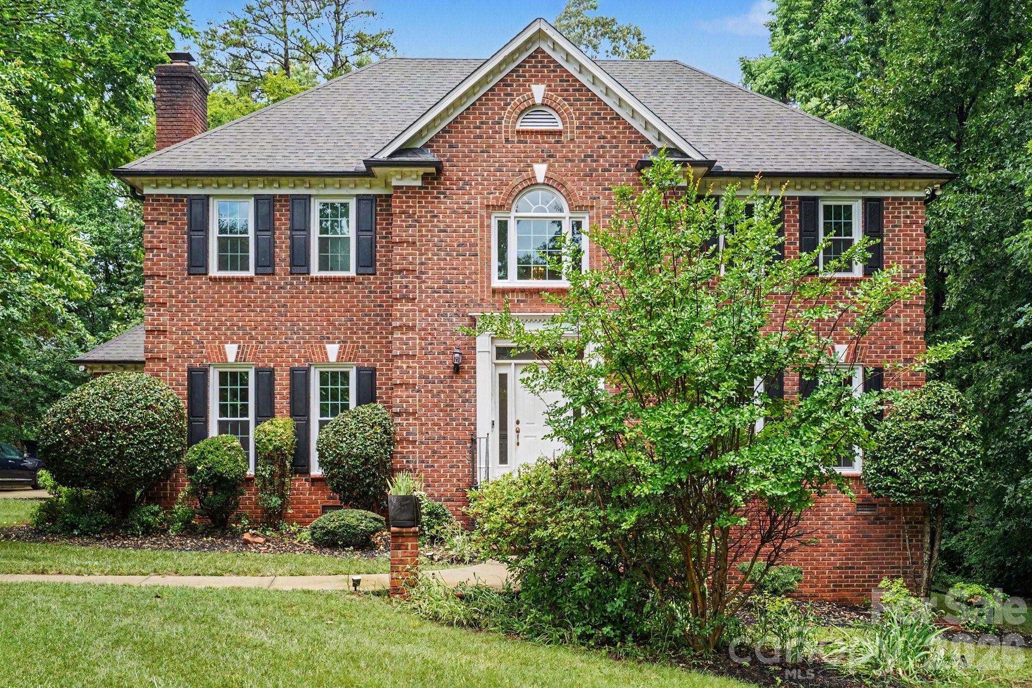 Nestled on a beautifully wooded lot in one of Harrisburg's most desirable neighborhoods, this custom brick home offers timeless craftsmanship, exceptional living space, and the privacy today's buyers are searching for. From the moment you step inside, you'll appreciate the rich hardwood floors, soaring ceilings, extensive crown molding, oversized windows, and spacious rooms filled with natural light. The thoughtfully designed floor plan offers formal living and dining rooms, a welcoming great room with a classic brick fireplace, and an expansive kitchen featuring abundant custom cabinetry, granite countertops, double wall ovens, a gas cooktop, a large center island, built-in desk, breakfast area, and generous storage throughout. The Upper-level primary suite provides a peaceful retreat with a tray ceiling, spacious sitting area, spa-inspired bath complete with dual vanities, jetted soaking tub, separate tiled shower, and a large walk-in closet. You'll also find generously sized secondary bedrooms with ample closet space and well-appointed bathrooms, offering comfort for family and guests alike. One of the home's true highlights is the stunning screened porch with a vaulted ceiling, where walls of windows overlook the private, tree-lined backyard—creating the perfect place to enjoy morning coffee, unwind in the evenings, or entertain year-round. The beautifully landscaped backyard offers a rare combination of open lawn space and mature trees, providing both privacy and room to play. Additional features include a side-entry two-car garage, abundant storage, a basement workshop/storage area, spacious laundry room, and quality construction rarely found in today's market. This is an incredible opportunity to own a custom-built home with outstanding bones, generous square footage, and endless potential to personalize in an established Harrisburg community just minutes from shopping, dining, schools, I-485, and Charlotte.