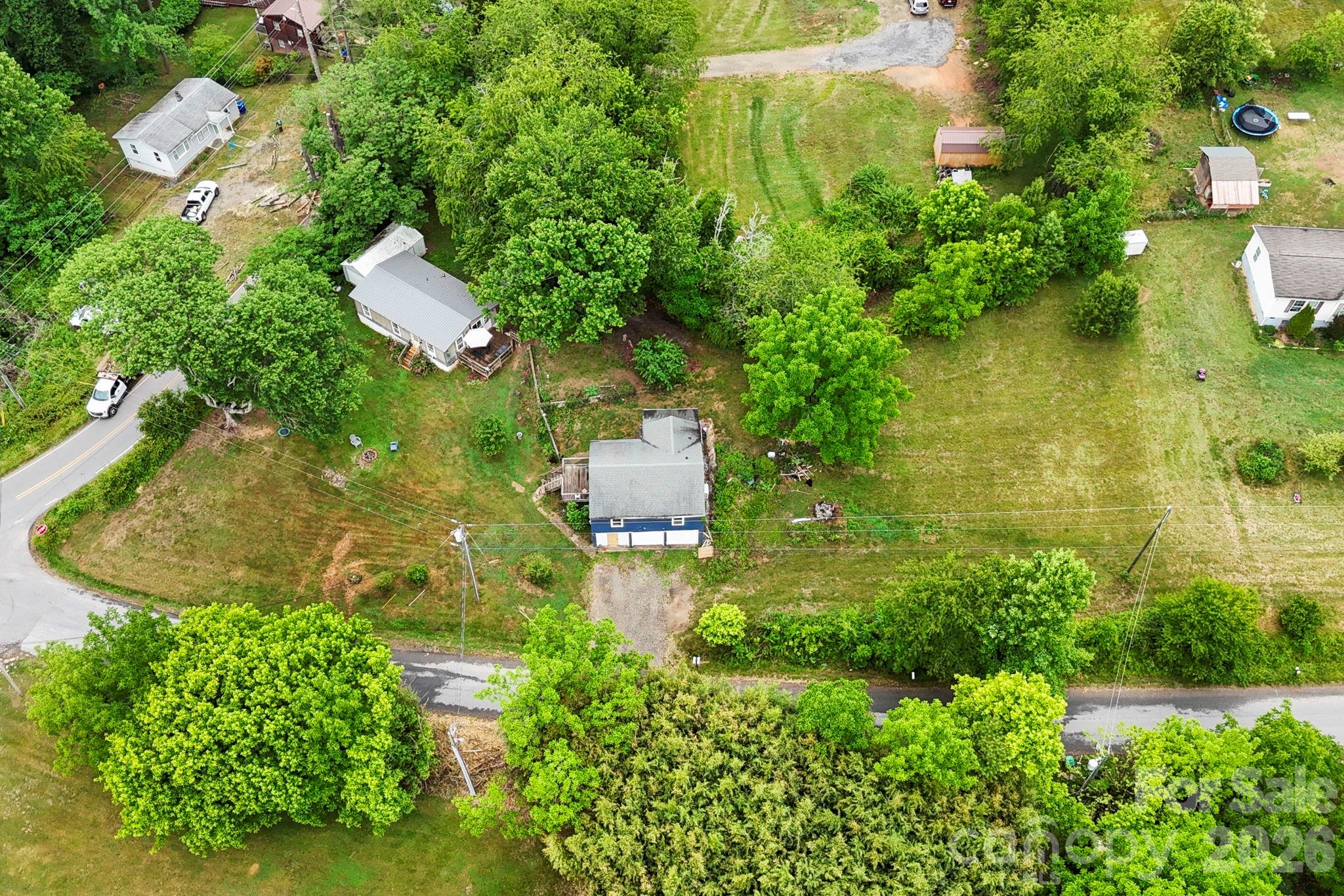 Rare multi-home opportunity in a prime West Asheville location offering flexibility, usable land, and future potential just minutes from everything Asheville has to offer. Located approximately 5 minutes from vibrant Haywood Road in the heart of West Asheville and just over 10 minutes to downtown Asheville’s celebrated music, food, and arts scene, this unique property combines convenience with space and privacy. The charming main bungalow features 2 bedrooms and 1 bath with beautiful hardwood floors, a newer HVAC mini-split system, abundant natural light, and timeless character throughout. Enjoy the inviting sunroom and spacious deck overlooking the peaceful setting. The lower level includes a double-car garage with ample room for storage, workshop space, or hobbies. Also included is a spacious 3 bedroom / 2 bath manufactured home, ideal for multigenerational living, rental income, guest accommodations, or investment possibilities. The expansive parcel offers access from two roads and includes a rare flat, highly buildable lot adjacent to the bungalow, creating additional development or expansion opportunities. Outdoor lovers will appreciate being just minutes from the recently protected 350-acre Deaverview Mountain property, offering access to nature and future recreational opportunities close to town. A truly versatile and hard-to-find West Asheville offering with multiple residences, usable land, and exceptional potential.