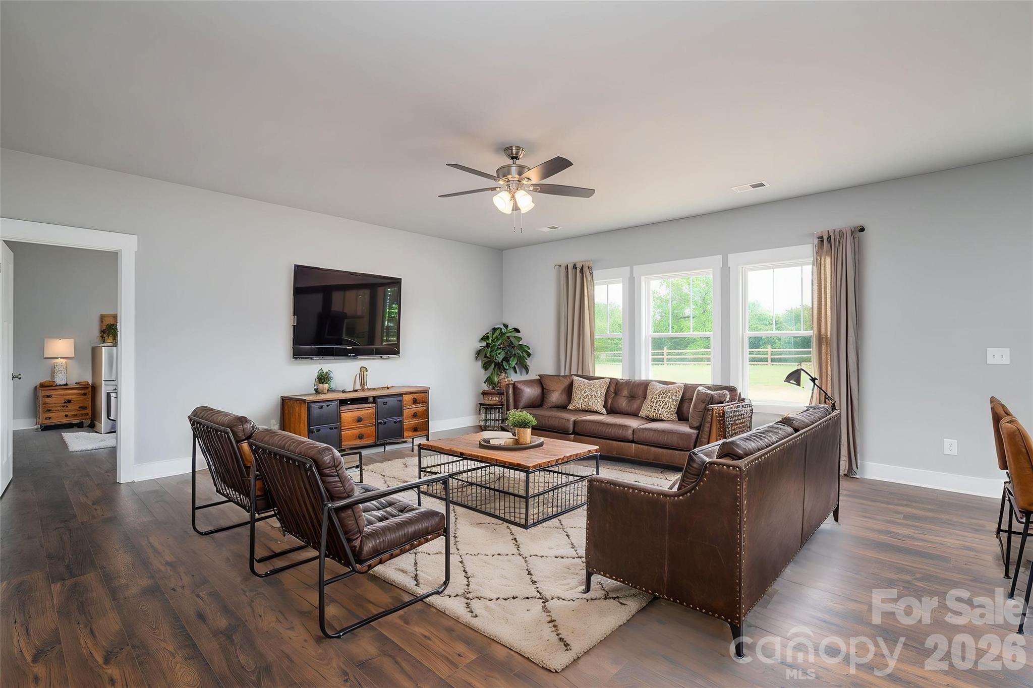 Builder is offering a $7500 buyer credit for this home for rate buy down and/or closing costs! This 4-bedroom, 2.5-bath single level residence blends modern style with everyday functionality—featuring no carpet throughout for a clean, upscale feel. Hardie board exterior accented with black trim for a clean, modern farmhouse look. The open-concept layout is filled with abundant natural light from expansive windows, creating a bright and inviting atmosphere. At the heart of the home, the spacious kitchen impresses with a large island ideal for gathering, soft-close cabinetry, walk in pantry, granite and sleek stainless steel appliances—all seamlessly flowing into the living and dining areas, providing plenty of room to spread out. A thoughtfully designed split-bedroom plan enhances privacy, highlighted by an oversized primary suite featuring a spa-like bath with dual vanities, a tiled shower with built-in seat, and a generous walk-in closet. Enjoy outdoor living from the welcoming front porch or relax on the rear patio overlooking the expansive, level yard. The oversized side-load garage, professionally epoxied, offers excellent space for a workshop, storage, or hobby use. Conveniently located with easy access to Highway 321, this home delivers the perfect balance of comfort, space, and accessibility.