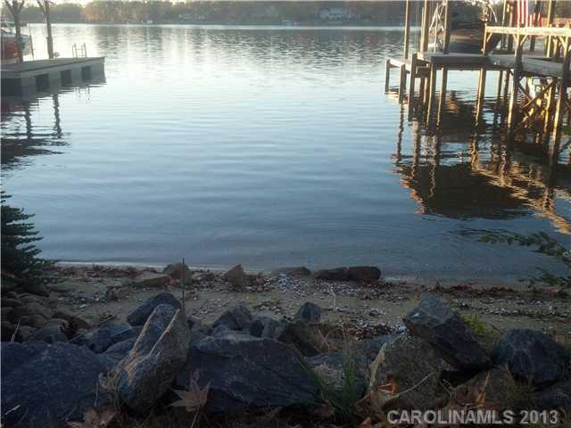 Beautiful view of deep waterfront lot located in community with beautiful custom homes. Community includes pool and clubhouse. Beautiful shoreline with a private sandy beach area perfect for entertaining. Boat lift and composite style decking. Unbelievable sunset views waiting for you!
