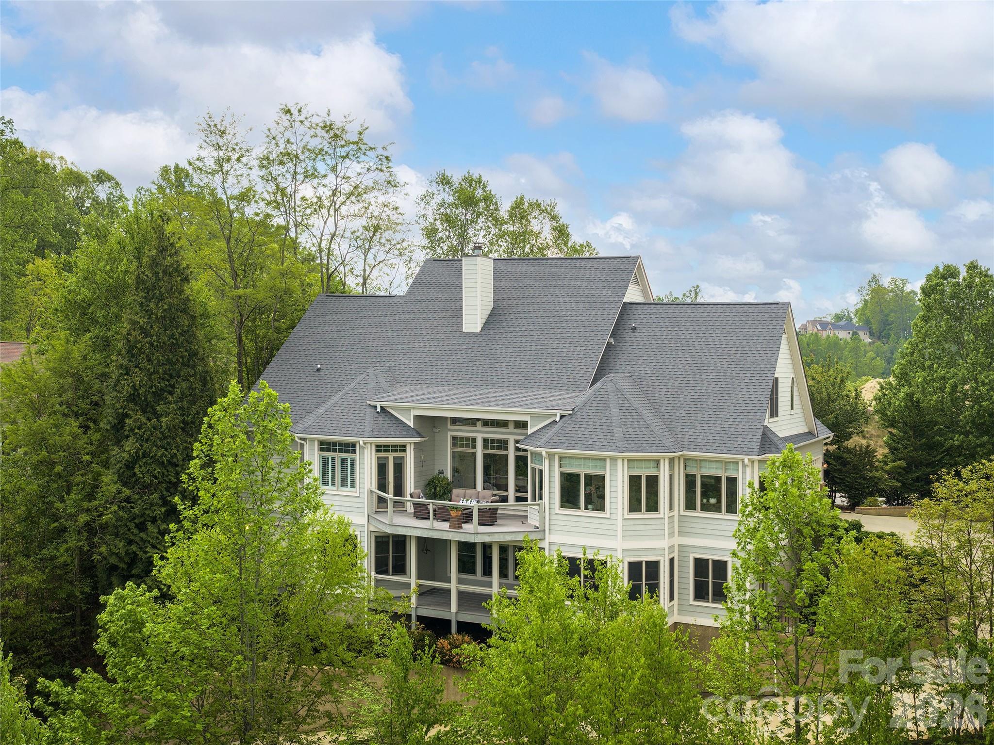 Enjoy year-round mountain views and luxurious comfort in this elegant mountain retreat located in the prestigious Carriage Park Gated Community. Featuring spacious interiors, soaring tray ceilings, elegant crown molding, custom cabinetry, stunning wood column accents, and premium 3 inch oak hardwood floors, this residence exemplifies quality and sophistication. Indulge your culinary passions in the gourmet kitchen, ideal for both daily meals and entertaining guests. Relax in the grand great room with panoramic mountain vistas and abundant natural light, or retreat to the luxurious primary suite with a spa-inspired bath, including a frameless glass walk-in shower and a Jacuzzi soaking tub. Private offices and guest spaces provide flexibility for your lifestyle, while the lower level offers a complete in-law suite with its own patio entrance. Exceptional home systems include an elevator for convenience, zoned HVAC with humidity control, circulating on-demand hot water, whole-house water filtration, and an automatic generator for peace of mind. Carriage Park residents enjoy an active lifestyle with access to a social clubhouse, year-round indoor pool, tennis and pickleball courts. Located just 3 miles from downtown Hendersonville, you're close to top restaurants, shopping, entertainment, and excellent medical facilities. Don't miss the opportunity to experience this extraordinary mountainside sanctuary designed by Stephen Fuller, one of the most prominent residential designers in the United States. View the video virtual tour for a closer look and schedule your private tour today!