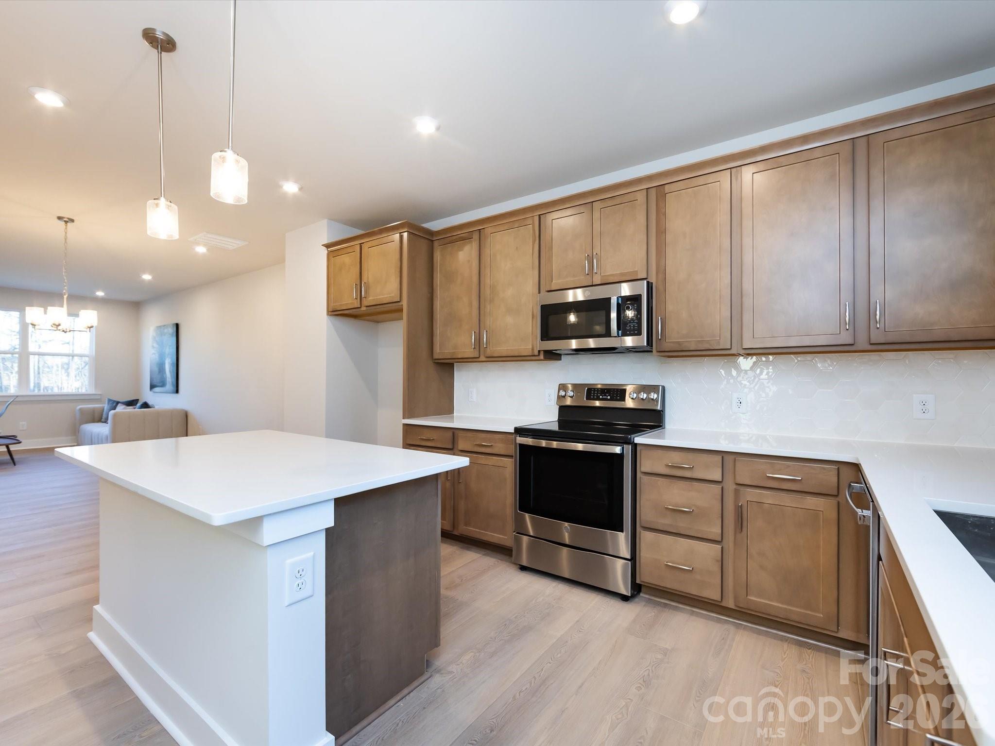 This brand-new Rockwell home is designed to feel bright, warm, and thoughtfully layered across every level. The lower level features a two-car tandem garage with added windows, creating an airy space with generous storage. The main living level centers around a welcoming kitchen with warm wood cabinetry, white quartz countertops, and light-toned flooring that keeps the space open and inviting. Upstairs, the primary suite offers a calm retreat filled with natural light, paired with a crisp white bath featuring modern tile at both the floors and shower walls. Appliances including the refrigerator, washer, and dryer are included, and oak box stairs on the first floor add durability and timeless appeal.