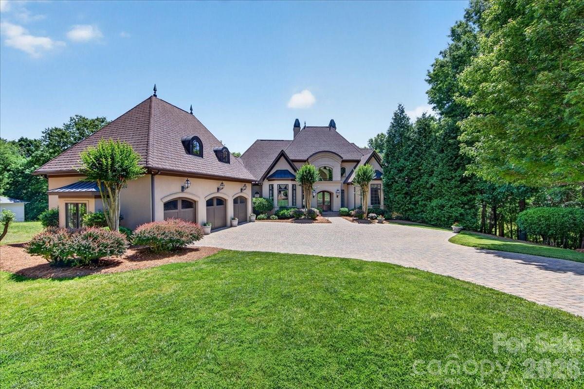LUXURY LIVING IN PELLYN WOOD! This custom residence built by Arcadia Homes, is a seamless blend of sophistication and luxury. Sun-filled interiors and soaring ceilings create an airy, refined backdrop, with lake views in almost every room. This home offers a thoughtfully designed floor plan with effortless flow for both entertaining and everyday living. Enter into a stately foyer and living room offering floor to ceiling windows with grand fireplace. Additional features include chef’s kitchen, island and walk-in pantry opening seamlessly to the breakfast area/bar. The main level also offers a private primary suite complete with gorgeous soaking tub, dual vanities, freestanding shower and sizable walk-in closet. You'll also find an inviting office, formal dining room, dual powder rooms and laundry on main level. Upstairs features three bedrooms complete with en suite baths and a large airy loft open to below. The basement level offers a versatile 2nd primary suite, theatre, exercise room and 2nd kitchen. Fireside billiard room opens to covered porch overlooking lake. Outdoor living is equally impressive, with a main level porch and lower level covered porch offering privacy and endless lake views. Lush and mature landscaping throughout adds both function and charm. Additional highlights include attached three-car garage, abundant walk-out attic storage, conditioned storage and a prime location just minutes from the shops and restaurants of SouthPark. Easy commute to Uptown.