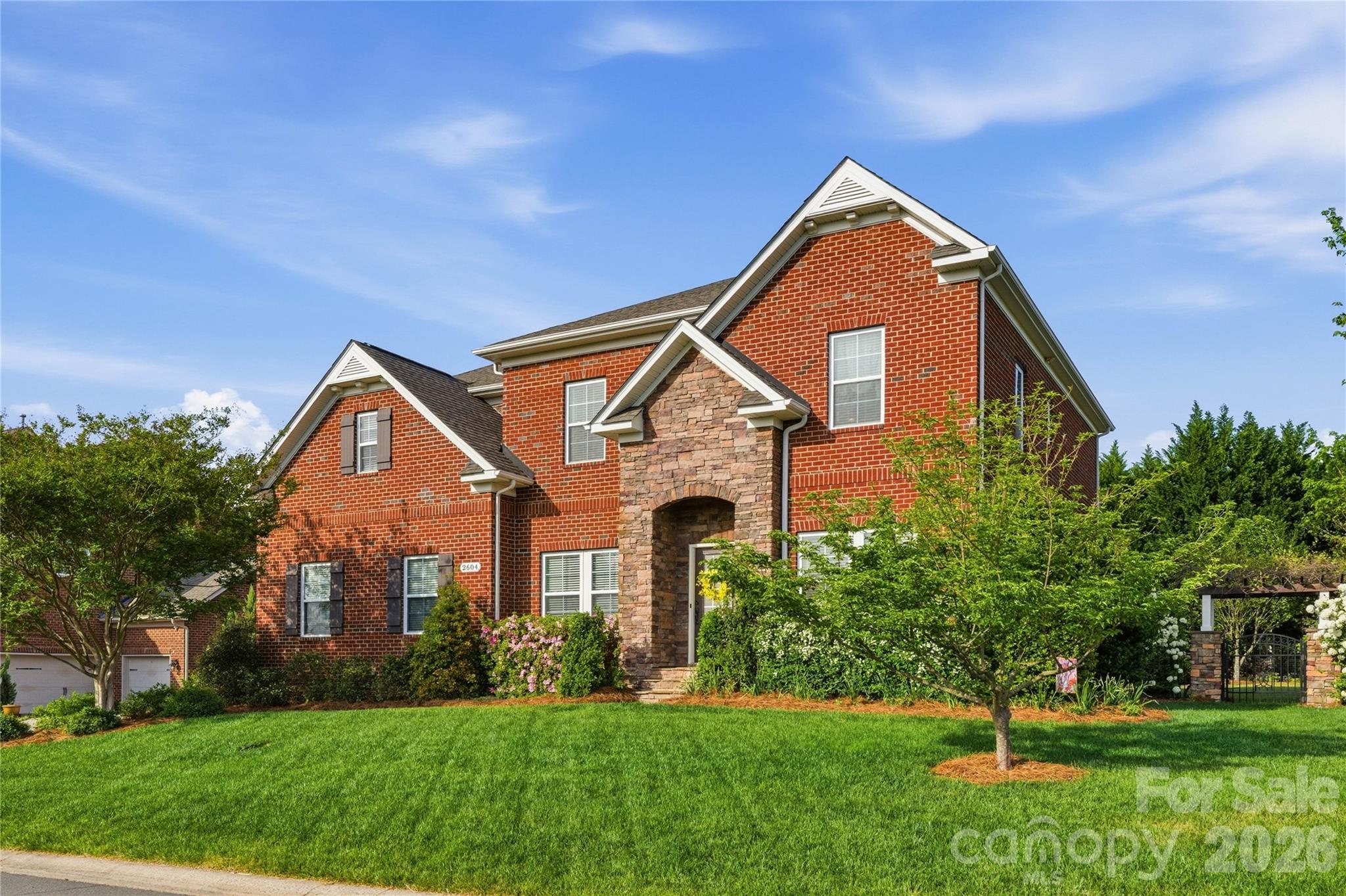 Welcome to 2604 McHanna Point, a beautifully maintained all-brick home located on a private corner lot in a quiet cul-de-sac in the highly desirable River Lake community in Tega Cay. This single-owner home offers 5 bedrooms, 3 full bathrooms, and 3,611 square feet of thoughtfully designed living space, combining comfort, functionality, and exceptional outdoor living. 

The main level features hand-scraped wood flooring, custom built-ins in both the living and family rooms, and a coffered ceiling in the formal dining room. The open-concept layout flows into a well-appointed kitchen with granite countertops, gas cooktop, double ovens, and a walk-in pantry—ideal for both everyday living and entertaining. A main-level guest suite provides flexibility for in-law living or extended stays. 

Upstairs, the spacious primary suite offers a private retreat. New countertops are being installed in the primary and guest bathrooms, and brand-new carpeting has been installed throughout the upper level (2026). Additional upgrades include new window screens (2026) and a tankless gas water heater (2026). 

Outdoor living is a standout feature of this home. The backyard is fully fenced with aluminum fencing (2017) and professionally landscaped for privacy with mature Leyland cypress, distylium, and ligustrum, along with fruit-bearing apple, fig, blackberry, and blueberry plants. The heated saltwater pool and hot tub (2021) features a 7-foot depth, waterfalls, and twin swim jets, surrounded by an expansive 800 sq ft travertine pool deck. 

The custom-built deck (2019) offers both covered and open-air living, including a screened-in porch with removable vinyl windows and a stone gas fireplace, as well as Trex decking with built-in lighting in handrails and steps and a gas line connection for an outdoor grill. A custom stone pergola (2017) adds additional outdoor entertaining space. 
Additional features include a 3-car garage (double + single) with 12+ ft ceilings for extra storage, in-ground irrigation system with a dedicated water meter (2018), and a well-maintained exterior. 

Ideally located near Nivens Creek Landing, where you can launch your canoe, kayak, or jet ski and enjoy direct access to the water-bringing a true lake lifestyle just minutes from your doorstep. Also close to Baxter Village, Kingsley, Tega Cay Golf Club, parks, and walking trails.
Approximately 30 minutes to Charlotte Douglas International Airport and 35 minutes to Uptown
Charlotte.

Zoned for the highly rated Fort Mill School District, including Gold Hill Elementary, Gold Hill Middle, and Fort Mill High School.