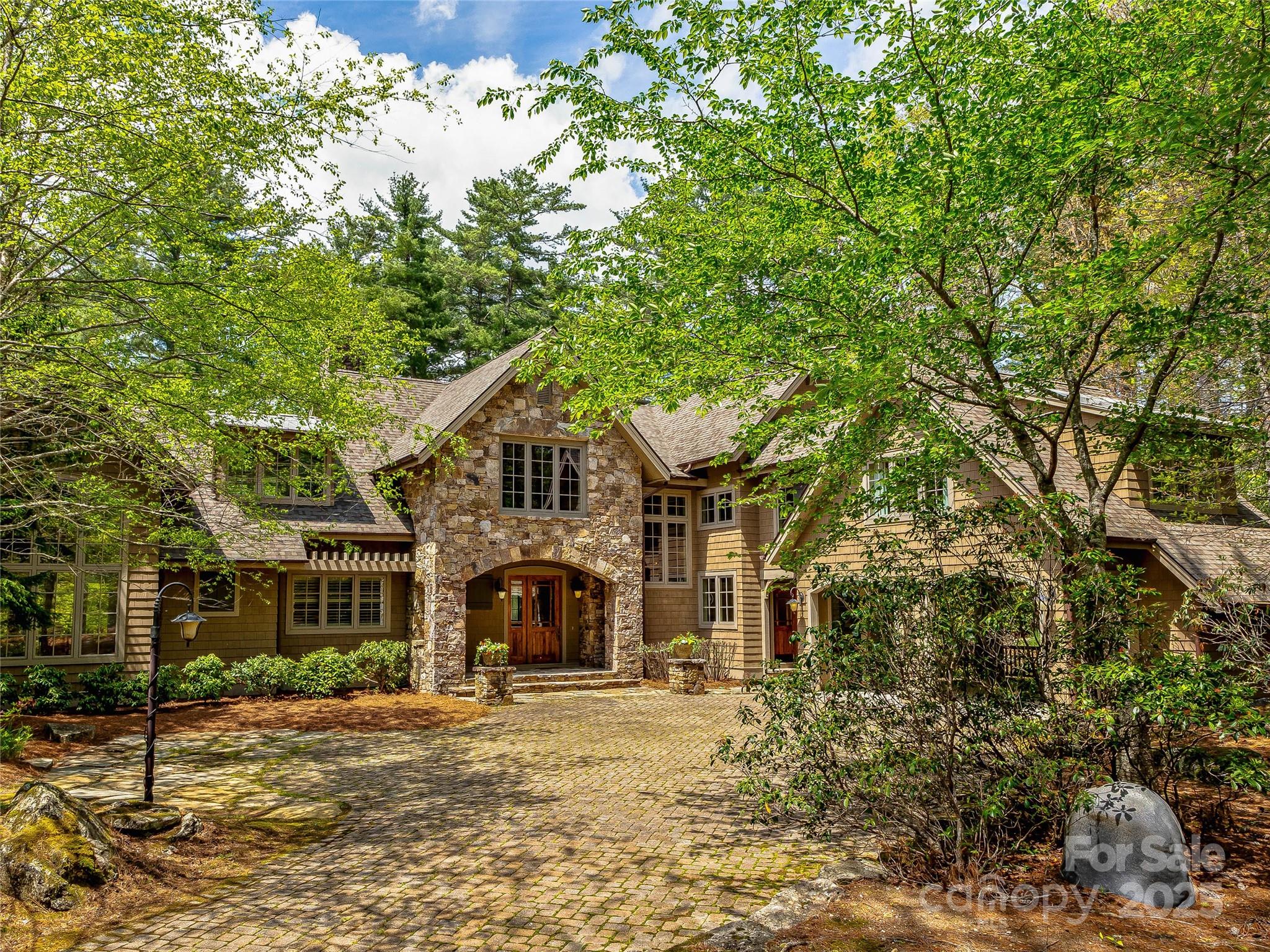 Overlooking the scenic 4th hole, this stunning 4-bedroom, 4.5-bath retreat is perfect for entertaining. The heart of the home is the expansive living room featuring a massive native stone fireplace and reclaimed timber trusses. The kitchen boasts stainless appliances, granite countertops, and ample storage space. The main level flows to the screened porch with a second fireplace, offering year-round enjoyment. Beautiful wide plank oak floors and custom mushroom board ceilings add rustic charm throughout, while wainscoting and thoughtful detailing elevate spaces throughout the home. The illuminated stairway leads to the upper-level bedrooms, a bonus room, and exercise room. The cobblestone paver driveway leads to the home’s entrance with abundant parking, a 2-car carport, and natural boulder landscape. Set in a serene, golf-side setting, this home is the perfect backdrop for unforgettable gatherings and everyday relaxation.
