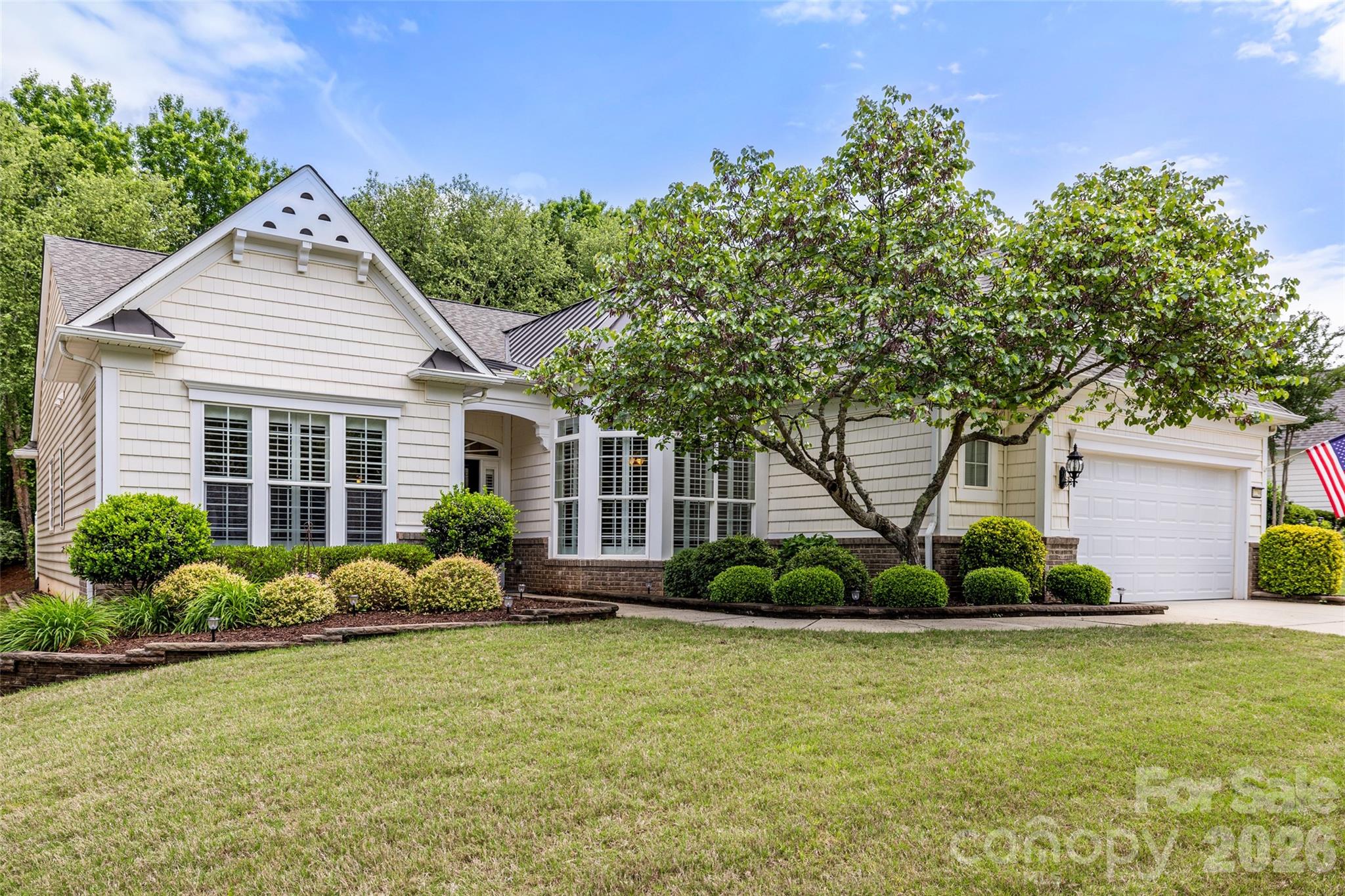 This sophisticated Cumberland Hall model in the premier Sun City Carolina Lakes community offers an exceptional blend of elegance and functional design. Featuring 3 bedrooms, 2.5 bathrooms, and a versatile layout perfect for the active adult lifestyle, this home is designed to impress.

The heart of the home is an open-concept chef’s kitchen, complete with rich cabinetry, premium granite countertops, a large central island, and stainless steel appliances. Large windows with plantation shutters fill the living and dining areas with natural light, highlighting the fireplace and detailed crown molding. Just off the entryway, double glass doors lead to a private home office, while the split-bedroom layout ensures maximum privacy for the primary suite.

Experience the pinnacle of indoor-outdoor living with the well-appointed 3-season room and outdoor entertaining area. The porch is a designer masterpiece, featuring a classic beadboard ceiling with dual fans and a magnificent floor-to-ceiling stacked-stone fireplace that serves as the perfect centerpiece for year-round relaxation. Step outside to find an additional patio space, perfectly suited for summer cookouts, large gatherings, and enjoying the serene, wooded backdrop.

Residents of this resort-style community enjoy access to world-class amenities, including an 18-hole golf course, tennis and pickleball courts, and multiple clubhouses. This home offers a seamless blend of sophisticated interior design and a premier outdoor setup built for hosting.