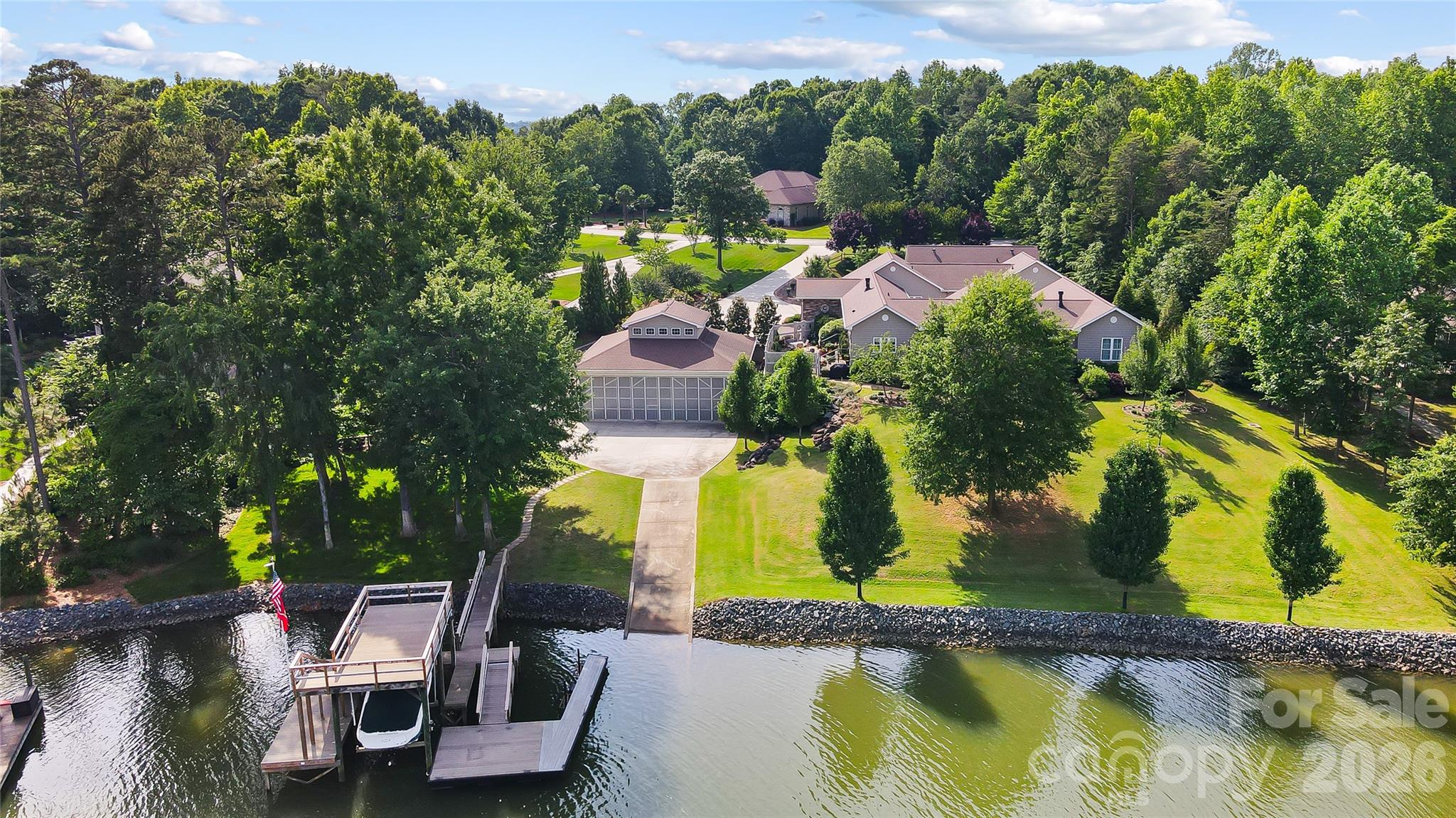 Experience the very best of Lake Wylie living in this exceptional waterfront estate, where luxury feels comfortable, inviting, and easy to enjoy. Designed with both everyday living and entertaining in mind, the home features a spacious island kitchen with gas cooktop and double ovens, a warm keeping room, and formal living and dining areas connected by a striking see-through fireplace. The main level offers a peaceful primary suite along with two additional bedrooms, plus welcoming spaces like a sunroom, sitting room, and reading nook that give the home a relaxed, lived-in feel.

The outdoor spaces are just as inviting. A resort-style courtyard pool is surrounded by expansive decks and porches, creating the perfect backdrop for quiet afternoons or lively gatherings. The finished basement provides even more room to spread out, complete with a second living area, bar, office, two additional bedrooms, a custom craft room, and abundant storage.

One of the property’s most distinctive features is the remarkable 43ft by 43ft garage, originally built as a seaplane hangar, while offering endless possibilities today for car collectors, boating enthusiasts, or anyone in need of an extraordinary workspace. It goes far beyond a typical garage and truly sets this property apart. There is also a detached building with two garage bays, great for an office or additional entertaining space.


Life on the water is effortless with your own private boat ramp, covered dock, tanning deck, and boat lift. Whether arriving by car, boat, or imagining the days of seaplane landings, this home offers a lifestyle that is both unique and memorable. Ideal for generational living and conveniently located for an easy commute to Charlotte Douglas International Airport, uptown Charlotte, medical offices, hospitals, dining, and grocery stores. Come home, this is a place where lasting memories are made.