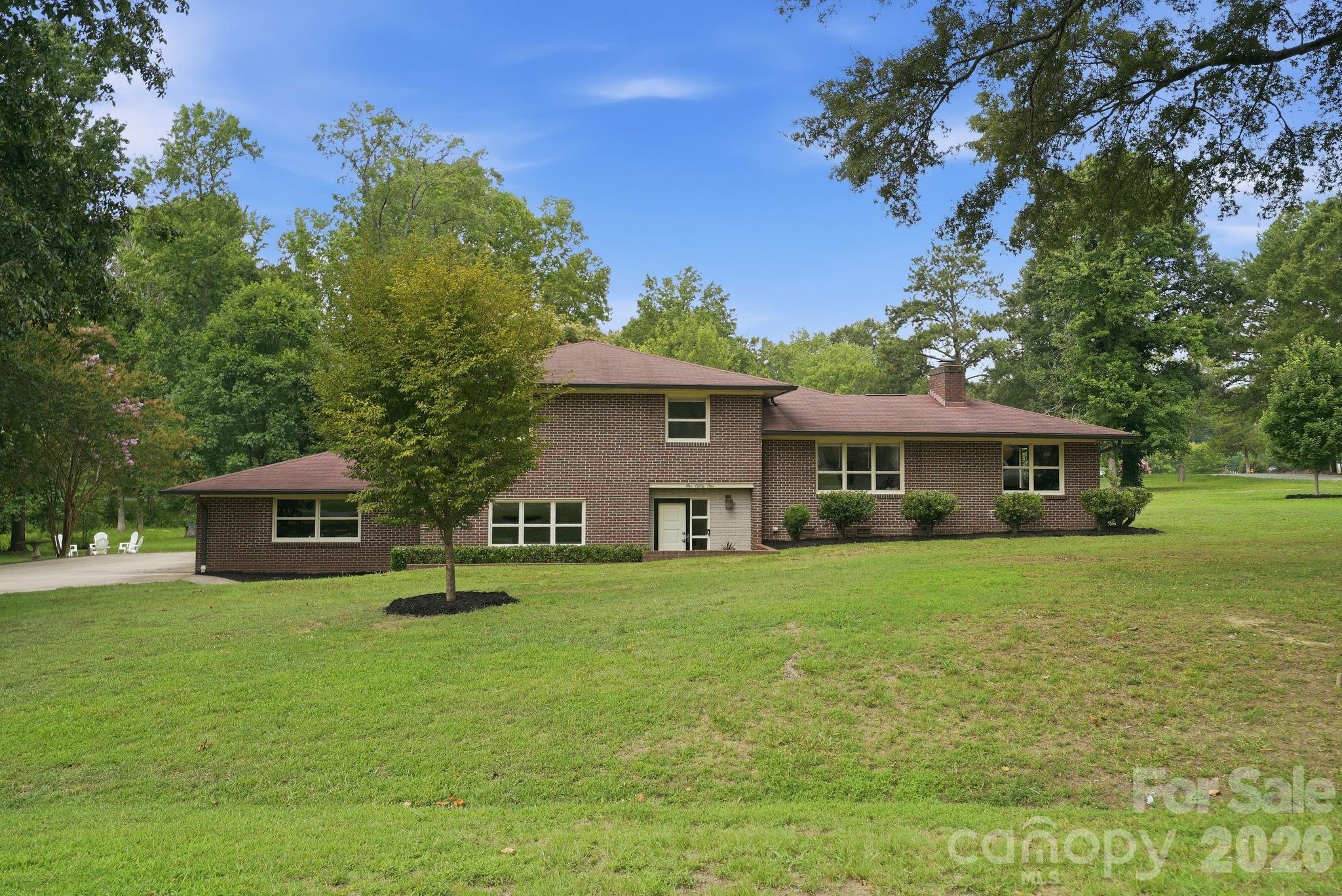 Beautifully curated, this mid-century modern split-level home is perfectly situated on a nearly one-acre corner lot in the sought-after Coulwood Hills community. Offering 4 bedrooms and 2 bathrooms, this residence seamlessly blends timeless architectural character with today's modern comforts, all surrounded by meticulously landscaped grounds and mature trees.
Some of the recent updates include refinished hardwood floors, fresh interior paint, numerous mechanical improvements, and a move-in-ready interior designed for modern living.
The welcoming foyer opens to a versatile lower-level den, currently used as a playroom but equally suited as a media room, home office, or second living area. This level also features a spacious mudroom/laundry room with abundant storage, along with a generously sized fourth bedroom renovated last year. 
Upstairs on the main level you’ll find the living room level is filled with natural light and anchored by a striking stone fireplace, creating a warm and inviting gathering space. Beautifully refinished hardwood floors and expansive windows provide a bright, neutral backdrop. A cased opening leads to the oversized kitchen, offering abundant cabinetry, generous prep space, and plenty of room for entertaining. The adjacent dining room is full of character with its terracotta tile flooring, original built-in cabinetry, and walls of windows overlooking the picturesque yard.
The upper level is dedicated to the private sleeping quarters, featuring two spacious secondary bedrooms that share a pristine hall bath with beautifully preserved original details. The primary suite offers an ensuite bath showcasing its original mid-century charm along with a custom closet system.
Outside, the meticulously maintained grounds create a private park-like retreat highlighted by a stunning Japanese maple, a productive fig tree, and mature landscaping that has been lovingly cared for over the years. The expansive corner lot provides exceptional space for gardening, entertaining, or simply enjoying the peaceful setting on your private terrace. 
Residents of this iconic neighborhood have the option to join the neighborhood park and pool without mandatory HOA dues. One of West Charlotte's best-kept secrets, the community offers incredible convenience to Uptown, major highways, Charlotte Douglas International Airport, and an abundance of shopping, dining, and recreation. Combining classic mid-century architecture, thoughtful updates, and an exceptional homesite, this is a rare opportunity to own one of Coulwood Hills' most distinctive homes.
