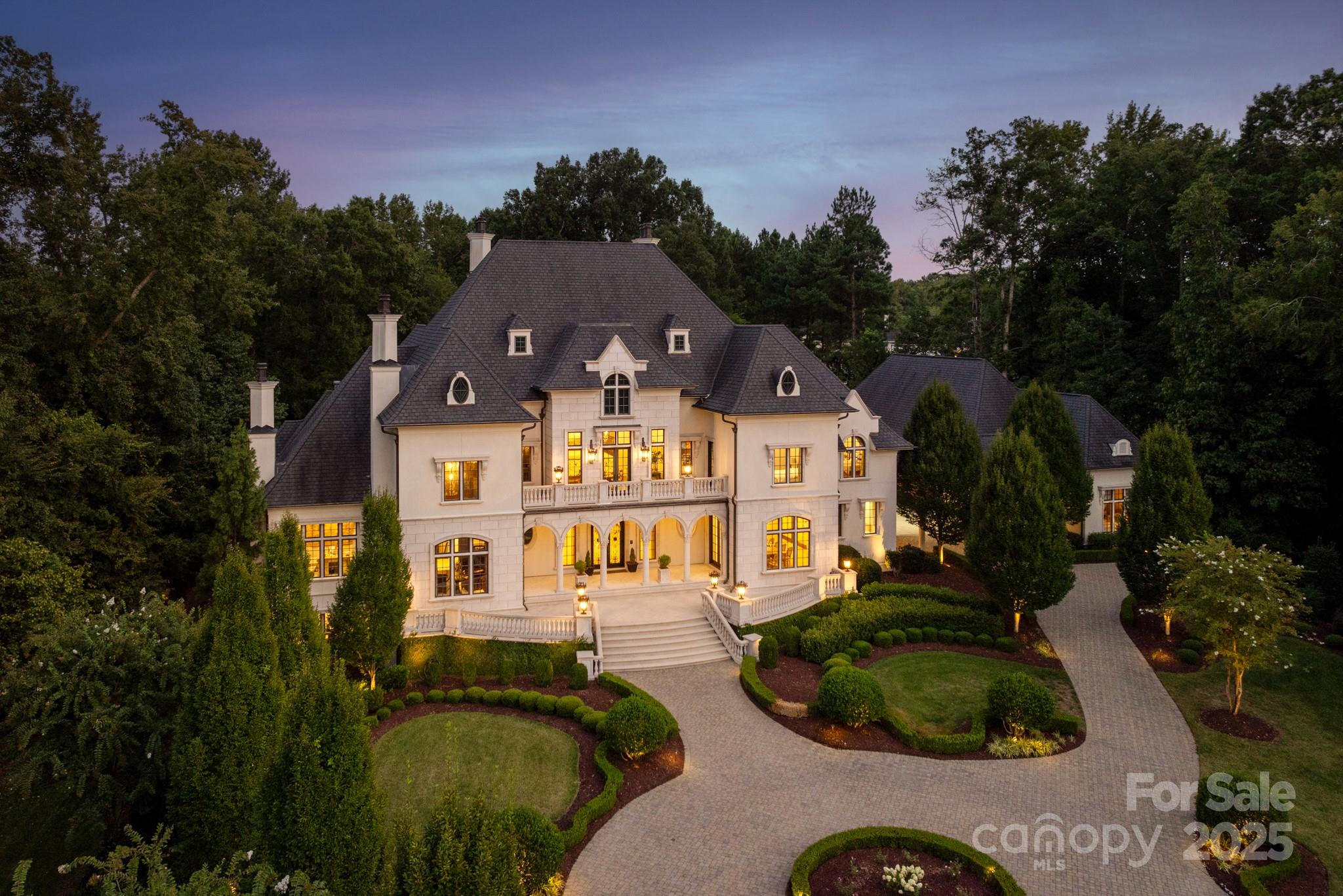 Indulge in the unparalleled quality and world-class design of this iconic French inspired chateau situated on 1.8 acres behind the gates in The Club At Longview. Every detail reflects the pinnacle of luxury living, offering a rare blend of classical architecture and modern refinement. The two-story library, enveloped in rich walnut paneling and featuring custom Habersham cabinetry, serves as a refined sanctuary, while the expansive 2-story great room exudes sophistication with its bespoke JP Weaver trimwork, soaring ceilings and 6' crystal chandelier. The open concept dream kitchen is a masterpiece of both function and design open to the family room and anchored by a grand marble top island, custom designed cabinetry and top-of-the-line Sub Zero, Wolf and Miele appliances. Enjoy a fully finished walk-out lower level with family room/bar, gym, movie theater and wine room. Resort style infinity pool is framed by English gardens and elegant archways leading to a carriage house for guests.