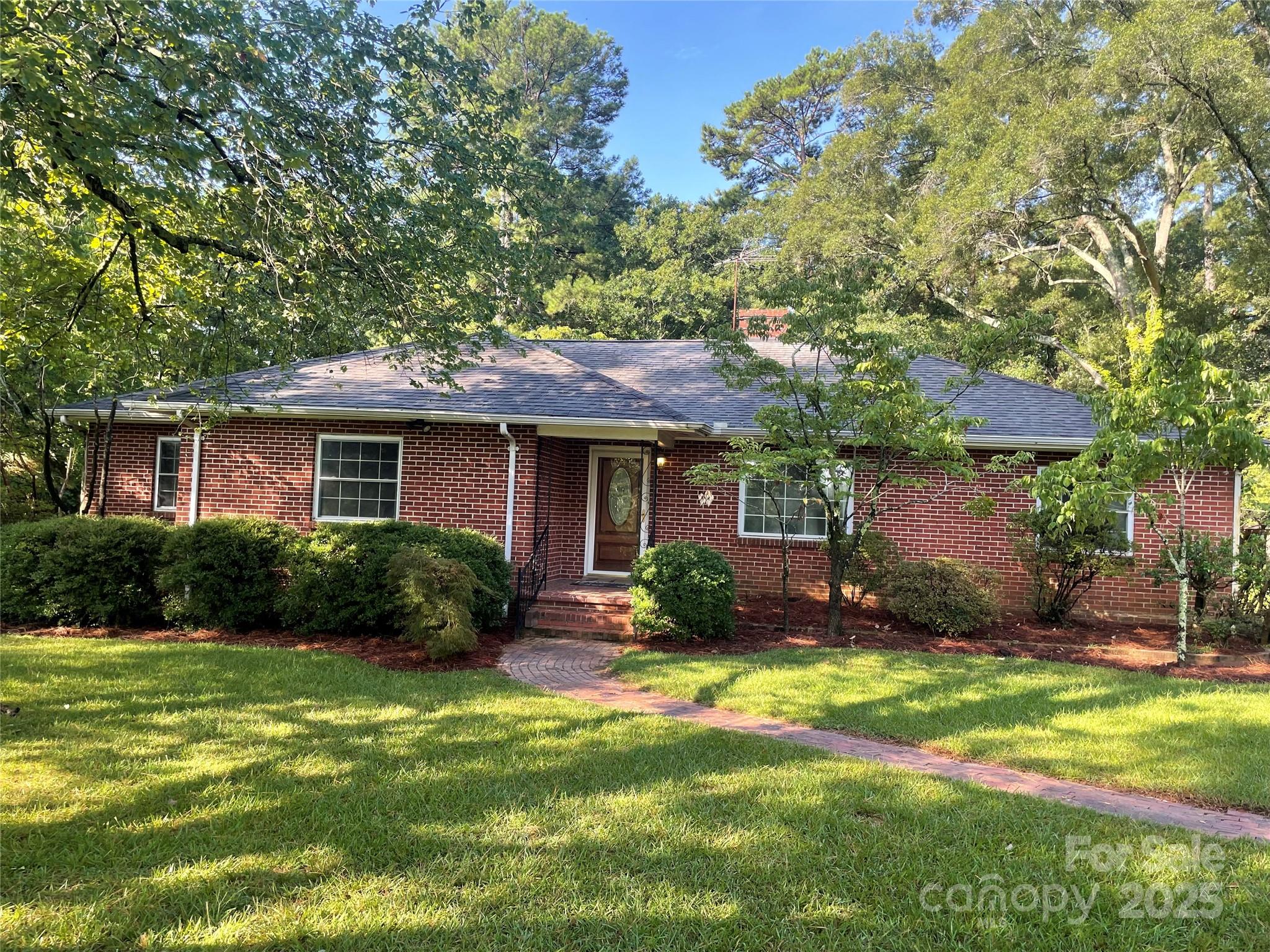 Lovely and gentle country setting with a home full of heart! Spacious field for gardening out front leading to a welcoming landscape at the home. Peaceful, private back yard with acres of trees behind with many possibilities. One story brick home (with only one owner) that has been filled with love and laughter over the years. Home features large rooms, with living room, den, and formal dining room. Hardwood floors in most of home, including under carpet is living room and dining room. There is a stackable washer/dryer in laundry closet in kitchen that will convey. Home is in a very convenient location, with proximity to I-77, dining, shopping, recreation, several hospitals, schools, and more. There are 2 mobile homes to the left of the home. One would be great for possible storage (or possible rehab).