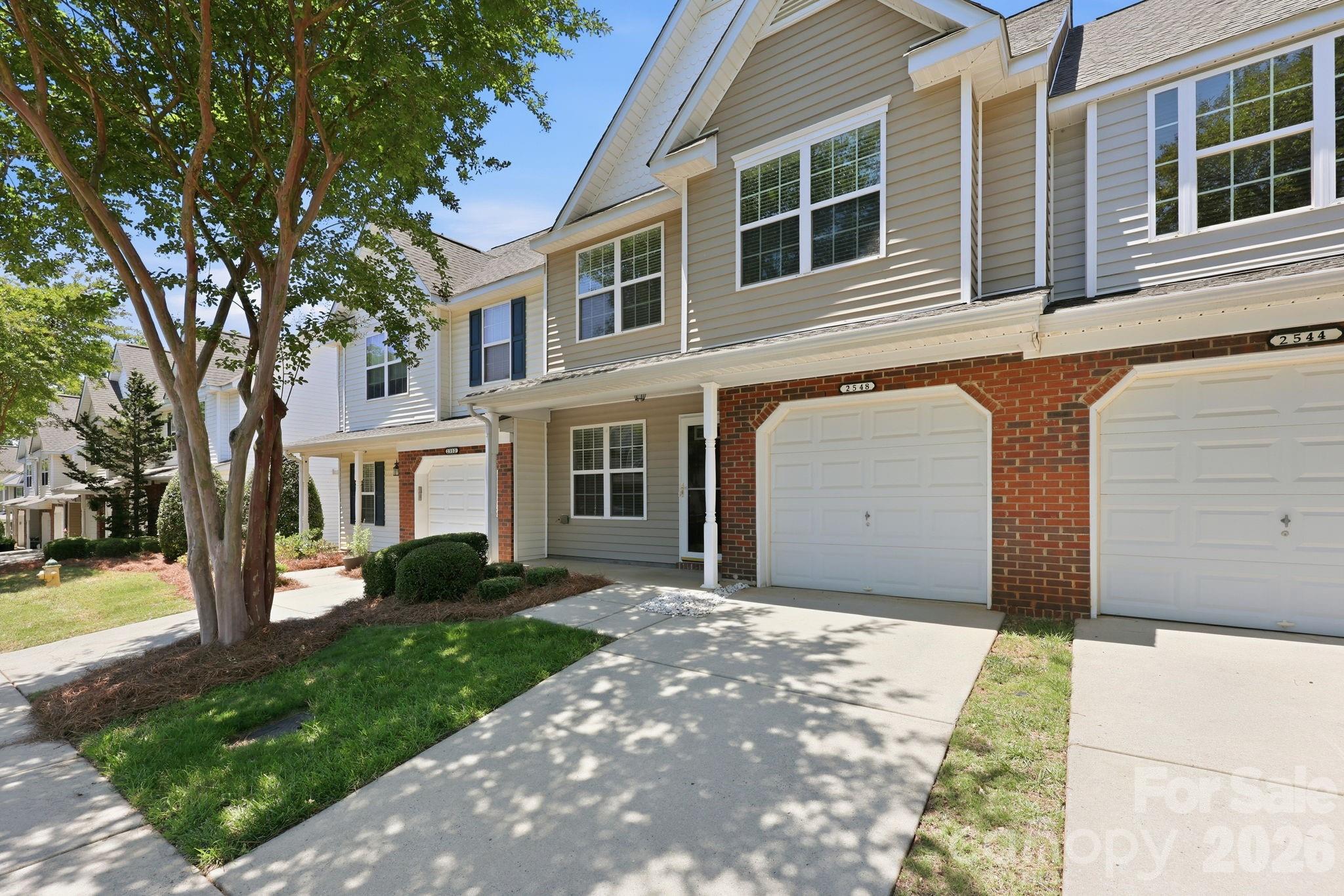 Move-in ready 3-bedroom, 2-bath townhome with fresh paint, LVP flooring throughout the main level, and a flexible floorplan featuring two separate living areas. The kitchen offers generous counter space, black appliances, and a functional layout designed for everyday living. Upstairs, the primary suite features vaulted ceilings, a walk-in closet, and an ensuite bath with a soaking tub/shower combination. Two additional bedrooms are well-sized and share a full bath. Enjoy outdoor living on the private patio, plus access to the community pool just in time for summer. Conveniently located near shopping, dining, and easy access to I-85.
