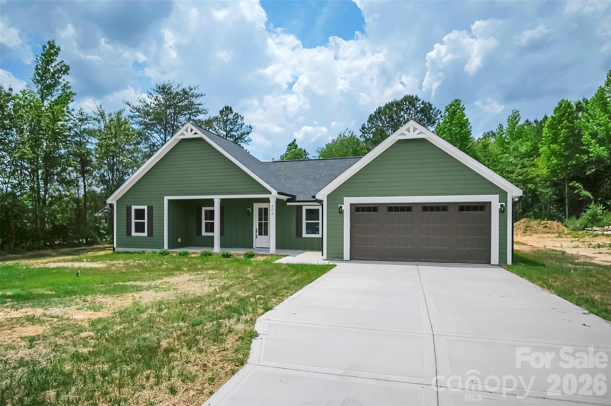 Beautiful new construction home featuring 3 bedrooms and 2 bathrooms with a desirable open-concept layout and split-bedroom floor plan. Exterior highlights include durable Hardie board siding, an 8-foot entry door, and a covered front porch perfect for rocking chairs. Inside, the home showcases luxury vinyl plank flooring, cathedral ceilings in the living room, and a seamless flow into the dining area and kitchen.

The kitchen is thoughtfully designed with stone countertops, gray shaker cabinetry, white subway tile backsplash, pot filler stainless steel appliances, center island, and a dedicated pantry with its own microwave circuit and low-voltage closet. The main living area also features a 12-foot sliding glass door that opens to a covered rear porch overlooking a private, wooded backyard, along with a 60-inch Wi-Fi-enabled LED fireplace.

The primary suite offers a walk-in closet and a well-appointed bath complete with dual vanities, a soaker tub, and a fully tiled walk-in shower with ceiling-height tile, waterproof no-mold grout, and custom fixtures with shower wand. Two additional bedrooms are located on the opposite side of the home and share a full bathroom with a tub/shower combination.

Additional features include pocket doors with soft open/close hardware, network wiring in each bedroom, “Smart Flow” gutter guards, and an extra-deep 24-foot garage with an 8x18 door. A well-built home combining modern finishes, functional design, and quality craftsmanship throughout.