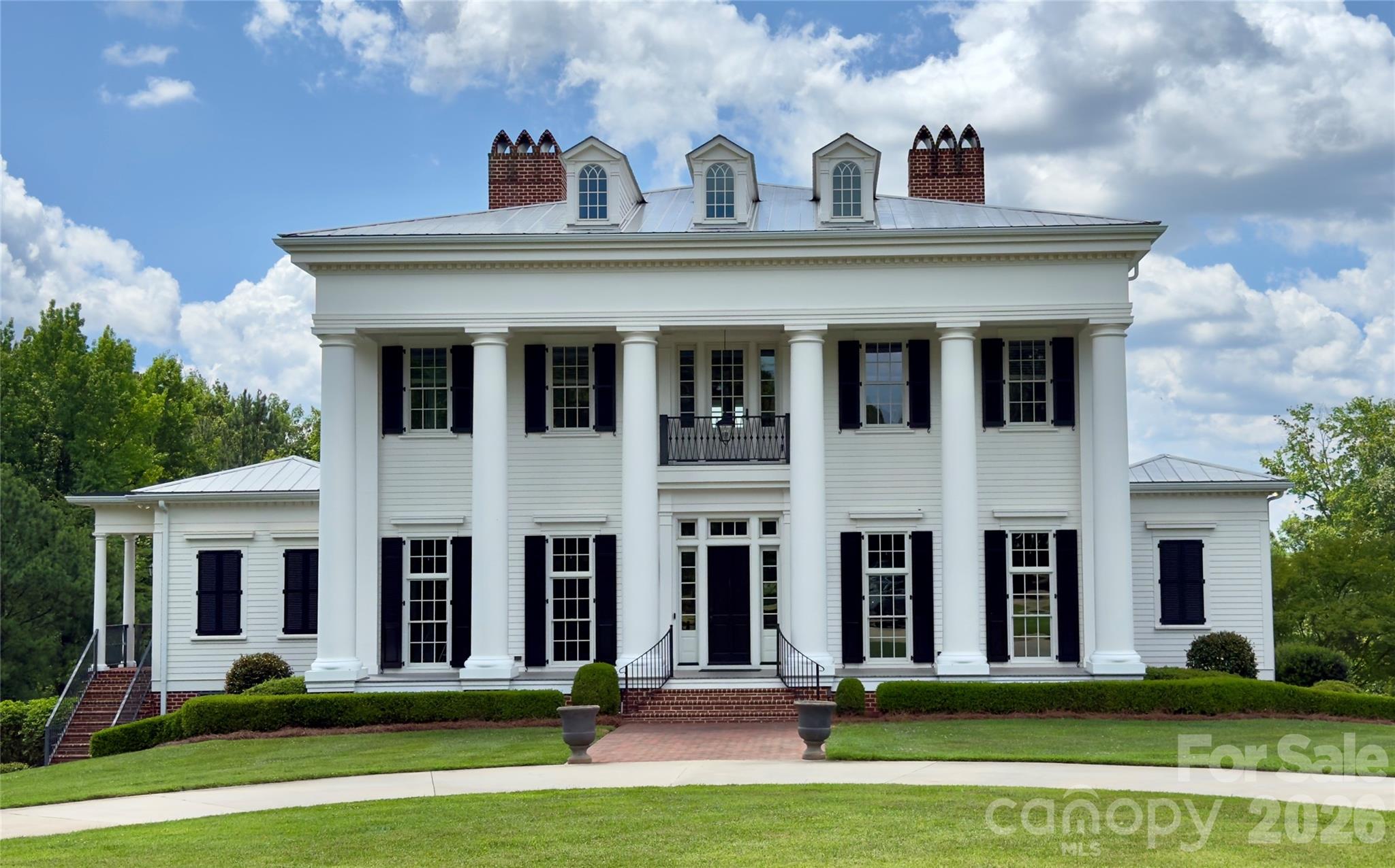 An extraordinary architect-designed Lake Norman waterfront estate where timeless craftsmanship meets modern luxury. Built in 2017 on 4.4 private waterfront acres, this historically-accurate and inspired custom home offers approximately 6,850 heated square feet across three finished levels, plus a walk-in attic ready for future expansion. 
Designed for both grand entertaining and everyday living, the home features 7 bedrooms, 7 full baths, 2 half baths, soaring 11-foot ceilings, three fireplaces (one is a large wood burning model with swinging cooking arm), RIM locks throughout the home (skeleton keys), formal living and dining rooms, a handsome library/office with custom built-ins, homework/craft room, billiards room, poker room, dedicated home theater, fitness room, and a walk-out lower level complete with a well-appointed custom wet bar. 
The chef's kitchen is appointed with a Wolf gas range, separate Sub-Zero refrigerator and freezer, custom cabinetry, and exceptional finishes throughout. The main-level owner's suite provides a private retreat, while an elevator shaft has already been incorporated into the design for future accessibility. The master-craftsman stairway has a continuous handrail that travels throughout all 4 stories leading from the basement to the walk-in attic.
Outdoor living is equally impressive with over 2,200 square feet of covered porches overlooking the water, an oversized custom saltwater heated pool and spa, pool lanai with a full bathroom, brick fire pit, water fountain feature (winterized), and professionally landscaped grounds accented by mature crape myrtles and white vinyl horse fencing. A circular driveway, four-car garage, and 40-foot RV cover provide exceptional convenience.
Enjoy the best of Lake Norman with a covered dock, double jet ski lift (convertible for a boat lift), dredged cove, riprap shoreline, and city water and sewer. Custom constructed with impressive 27-foot architectural columns on the front and rear, this one-of-a-kind residence delivers unmatched quality, privacy, and waterfront living.
A rare opportunity to own one of Lake Norman's most distinctive custom estates.