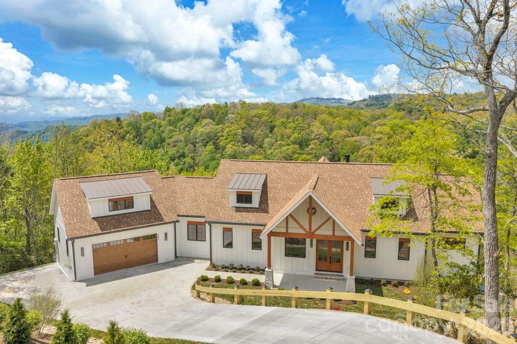 The Overlook at Greystone: NEW CONSTRUCTION with quality craftsmanship & GREAT floor plan between Boone and Blowing Rock, with long-range, layered Blue Ridge Mountain views, including views of Grandfather Mountain & the John's River Gorge (full view control from both upper and lower decks)! Discover a great year-round residence or mountain getaway featuring a combination of contemporary, mountain, and rustic styles. Located in the gated community of Greystone IV and offered as a double-lot combination of close to 2 acres, this home is easily accessible year-round on paved roads. The foyer immediately opens into the Great Room with cathedral, tongue & groove ceiling, stone fireplace, and wall of windows for taking in the views. Step outside onto the partially open, partially covered, and expansive main-level deck as the living area flows from indoors, to out! The open dining area and kitchen with walk-in pantry, kitchen island, and high-end appliances are adjacent to the Great Room with mudroom, office, full bath, half bath, and attached two-car garage all on the walk-in level. The main-level primary suite offers a walk-in closet with laundry nook, full bath with double vanity and tiled shower, and adjacent office or bonus room. Downstairs, a second living room offers a stone fireplace, kitchenette, views from indoors, and covered deck. The lower level also offers two suites, both with walk-in closets and tiled showers, and one with deck access, in addition to a bedroom, an additional full bath, and spacious 2nd laundry area. Additional features: high elevation (3,680+ feet!), covered front porch/entry, marble, quartz, and granite counters throughout, white oak flooring on main level, luxury vinyl plank flooring on lower level, floating staircase at entrance, Scottsdale interior doors, Top Knobs kitchen hardware, and more! Home is constructed on 1 lot, with the 2nd lot currently offering added privacy and acreage, but also providing potential as a 2nd buildable lot with gorge views.