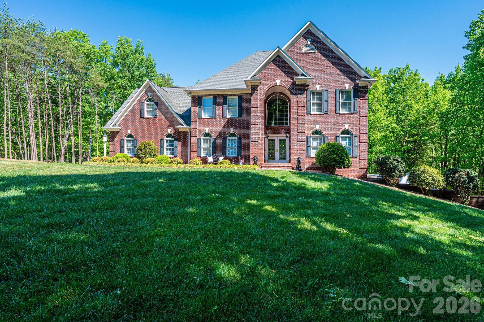 This beautifully designed, custom built & one owner 3BR, 3.5BA home with a bonus room/office offers the perfect blend of space, comfort, and flexibility for multi-generational living. The main level features a convenient half bath, while the upper level includes two full baths. The fully finished lower level adds another kitchen, rec room/den and full bath that is ideal for extended family or guests. Enjoy peaceful views from the deck overlooking approximately 3.5 private acres, or relax on the covered lower-level porch complete with ceiling fans. With separate driveways for both the main and lower levels, this home offers added convenience and privacy. Inside you will find hardwood flooring throughout the main and upper levels, tile flooring in the lower level and high ceilings that create an open, airy feel. The main and lower levels feature a gas log fireplace. The kitchen is a standout with beautiful cabinetry, granite and a center island with a cooktop that's down drafted. All appliances in both kitchens remain. All hardwood & ceramic tile - No Carpet!